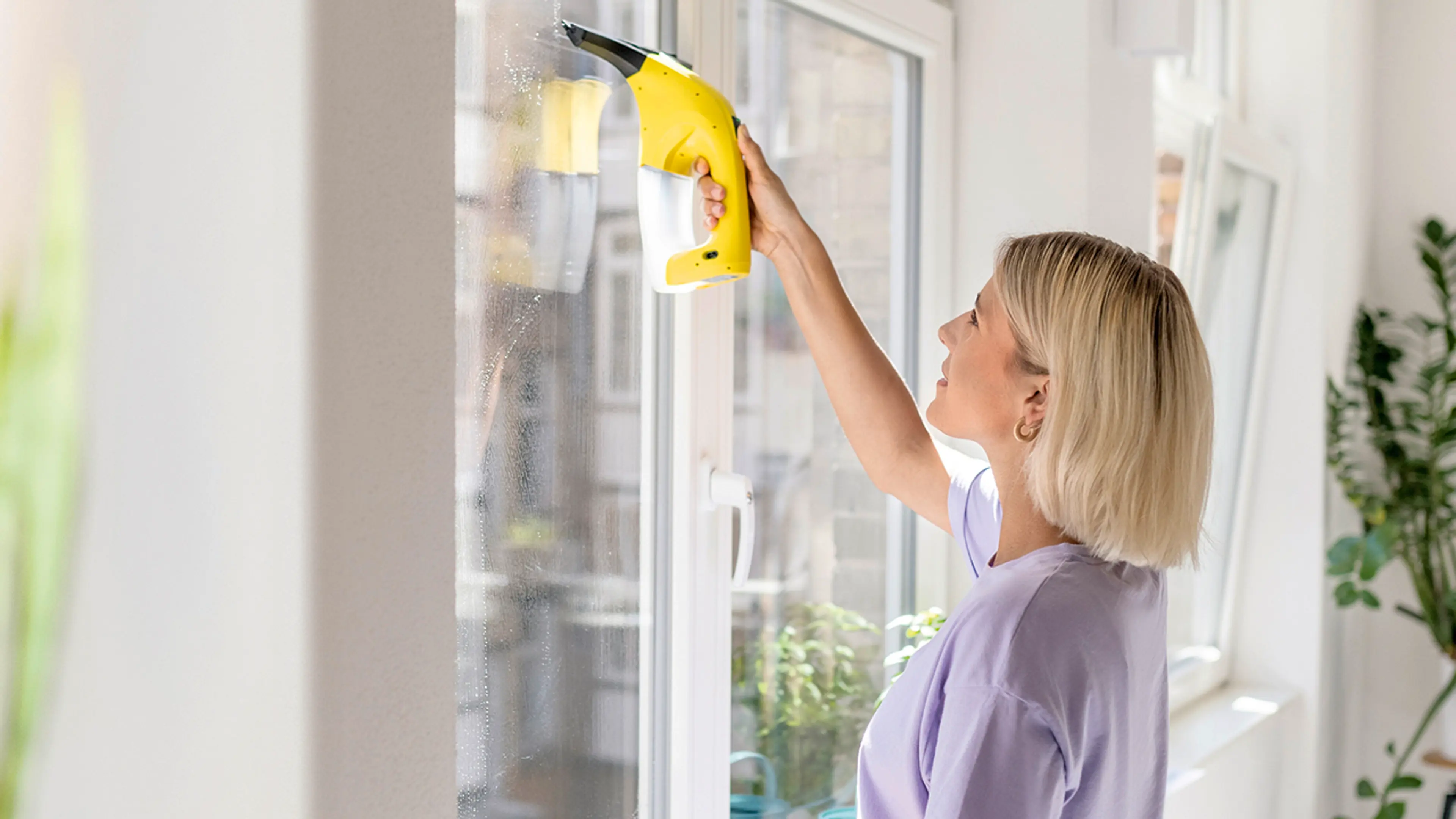 Kvinne som viser hvordan vaske vinduer med vindusvasker.