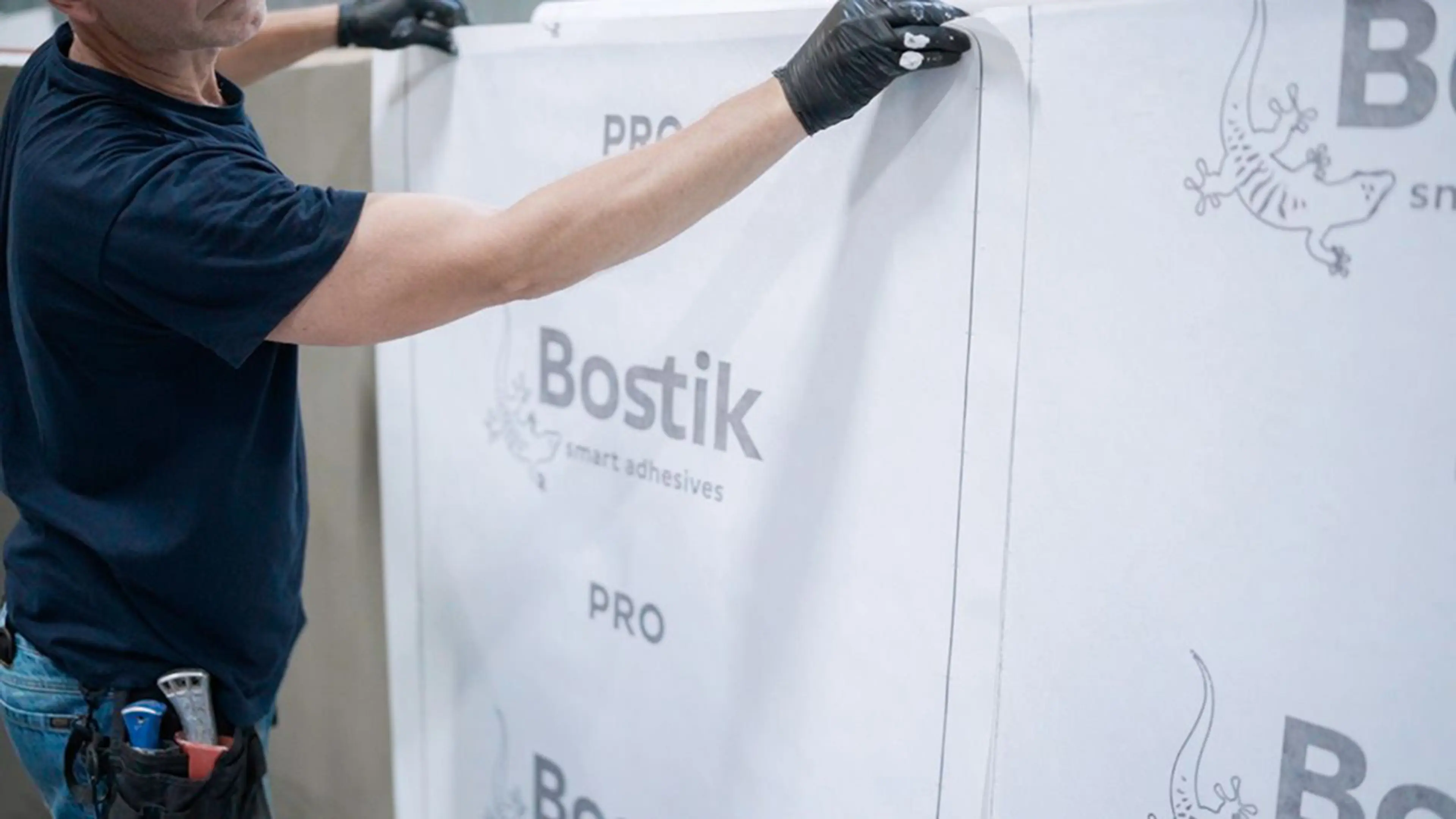 Bostik PRO vanntettingssystem som festes til vegg av mann med hansker.