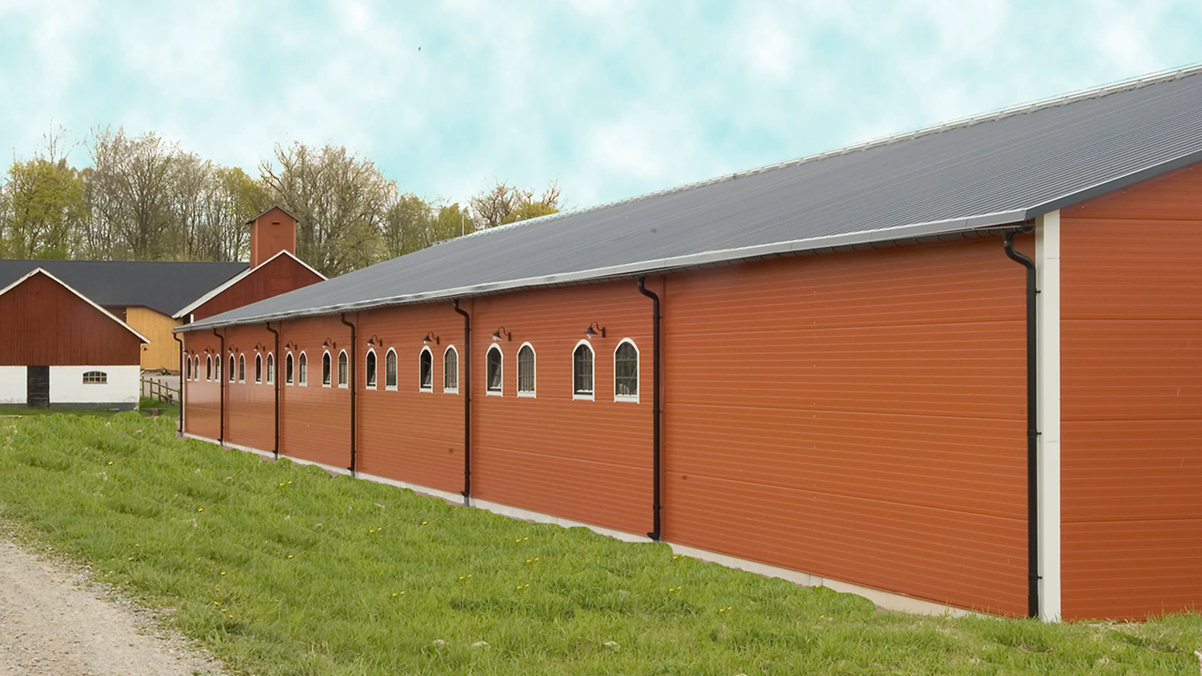 Orange stall med sorte takrenner.