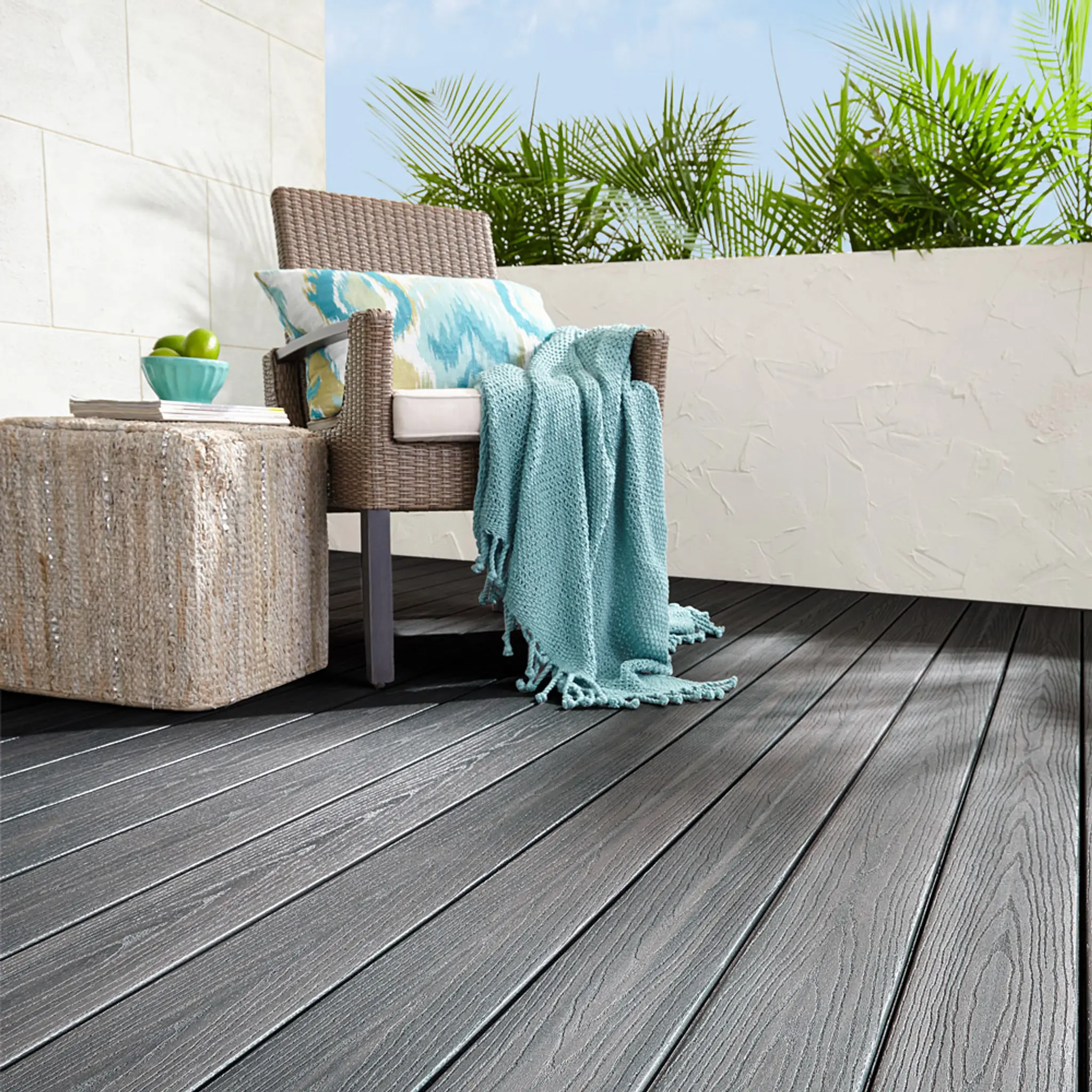 Kurvstol og bord står i et hjørne på en kompositt terrasse bygget med Fiberon Goodlife i fargen Beach Club.