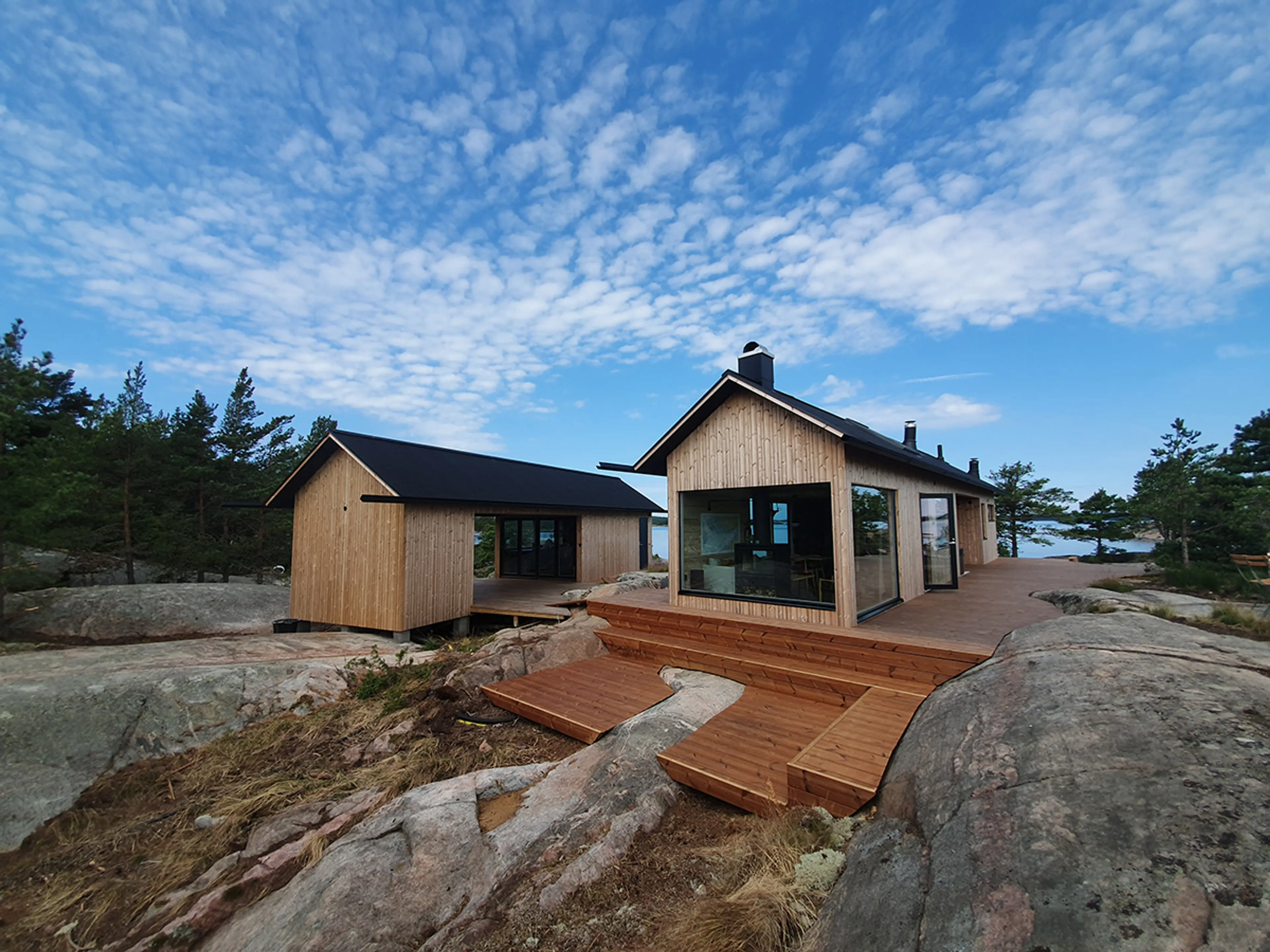 nybygget hytte og anneks ved sjøen, med termofuru som kledning