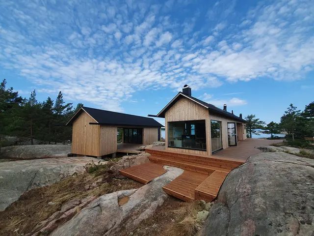 nybygget hytte og anneks ved sjøen, med termofuru som kledning