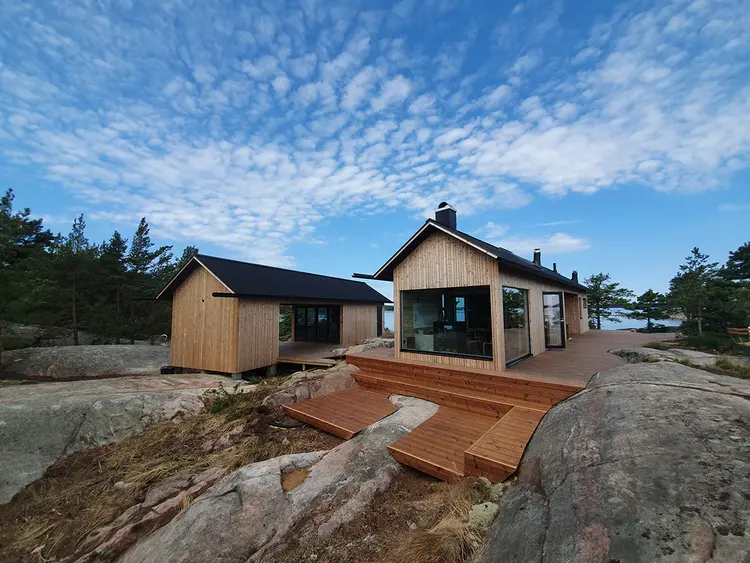 nybygget hytte og anneks ved sjøen, med termofuru som kledning