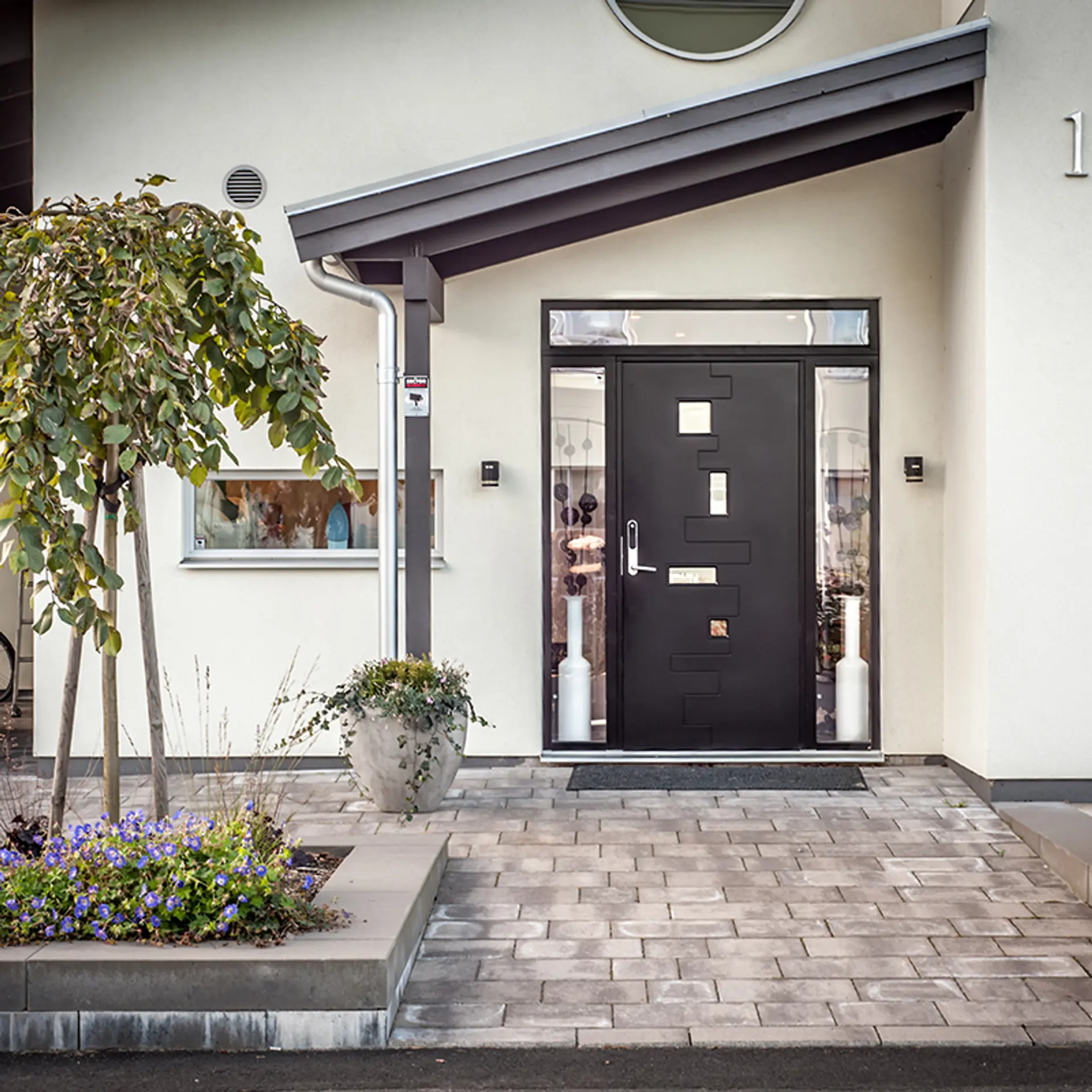 hvitt murhus med sort ytterdør