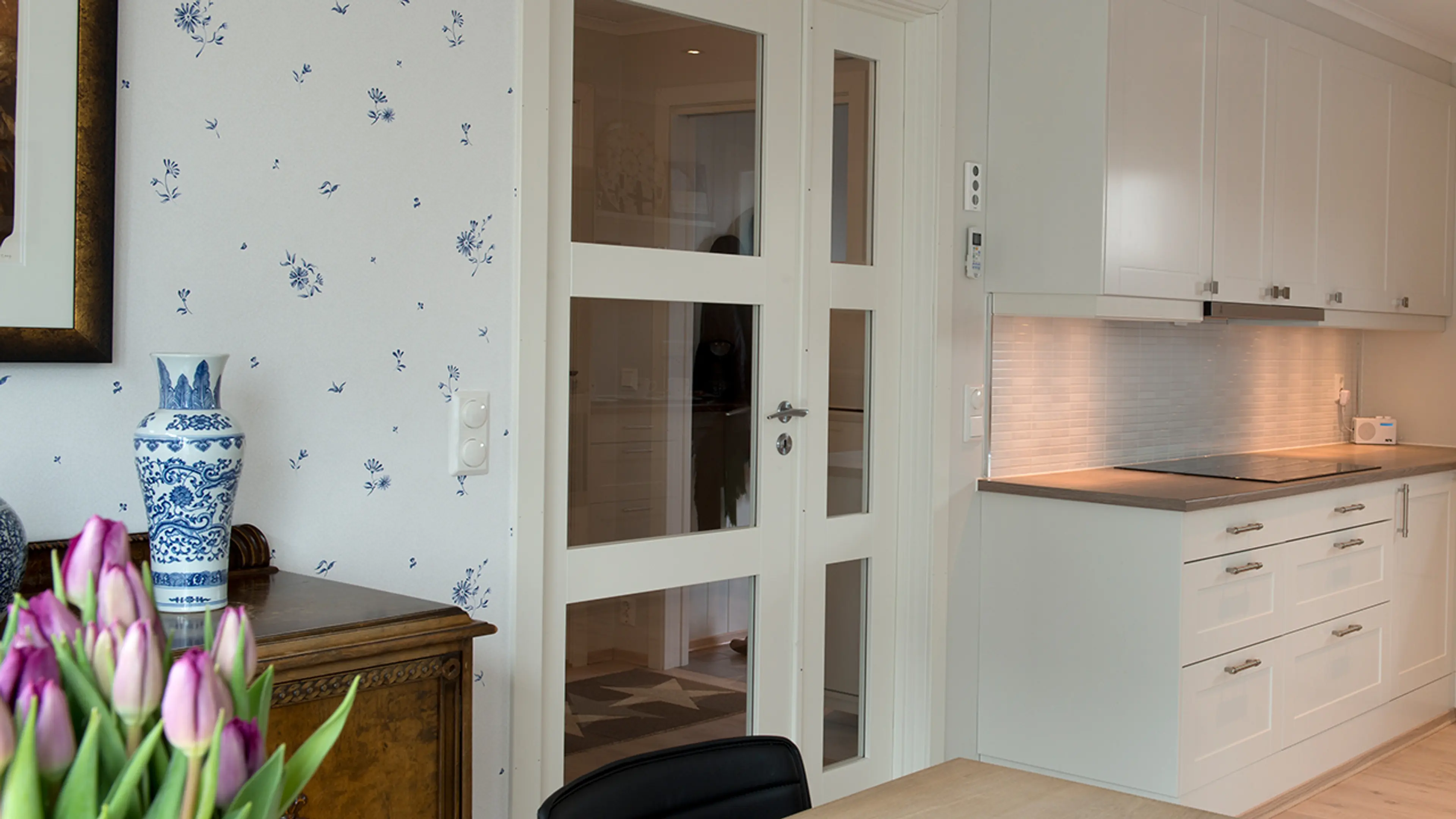 Kjøkken med innerdør i glass og sidefelt.