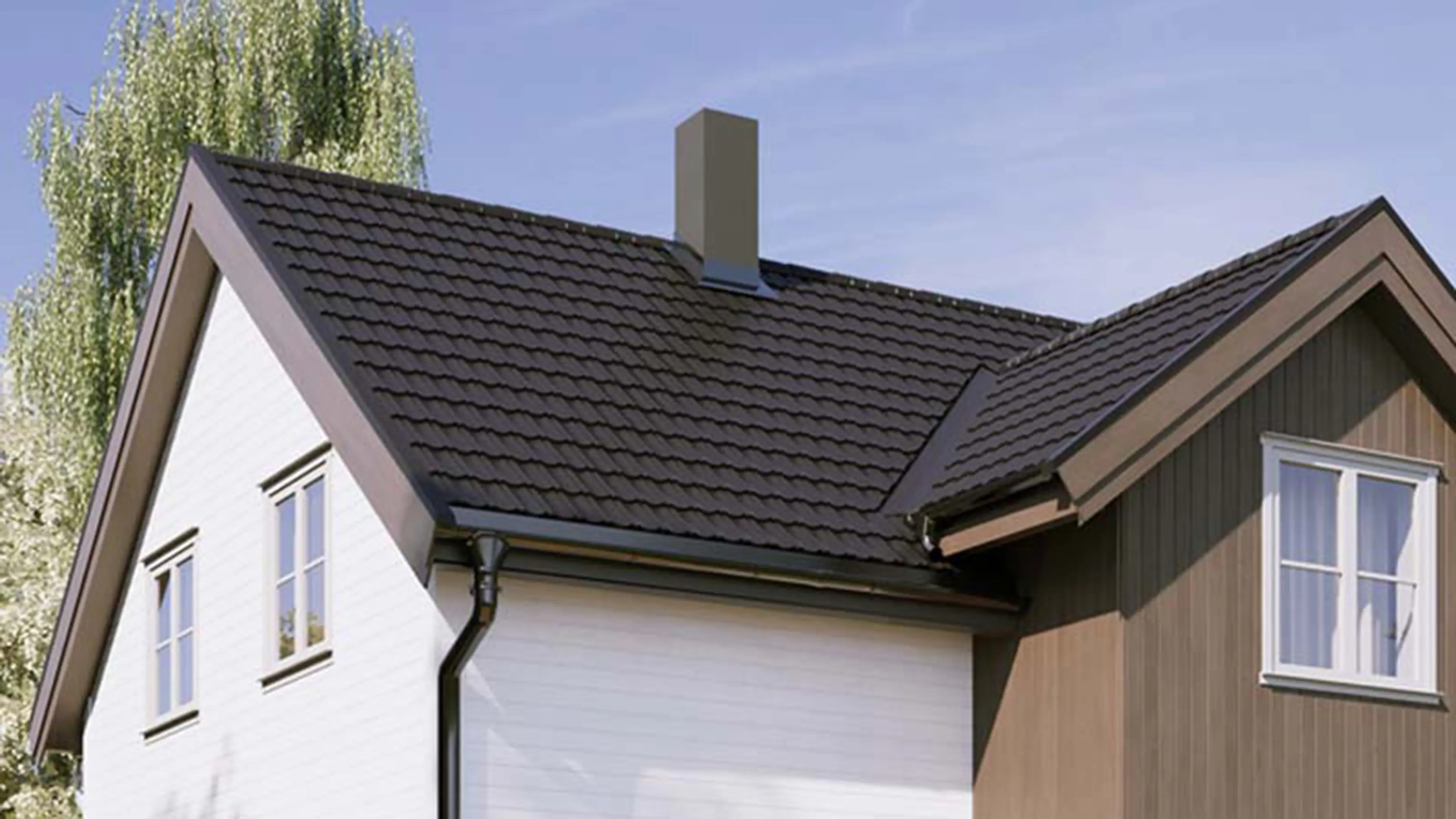 Hvitt og brunt hus med takpanner.