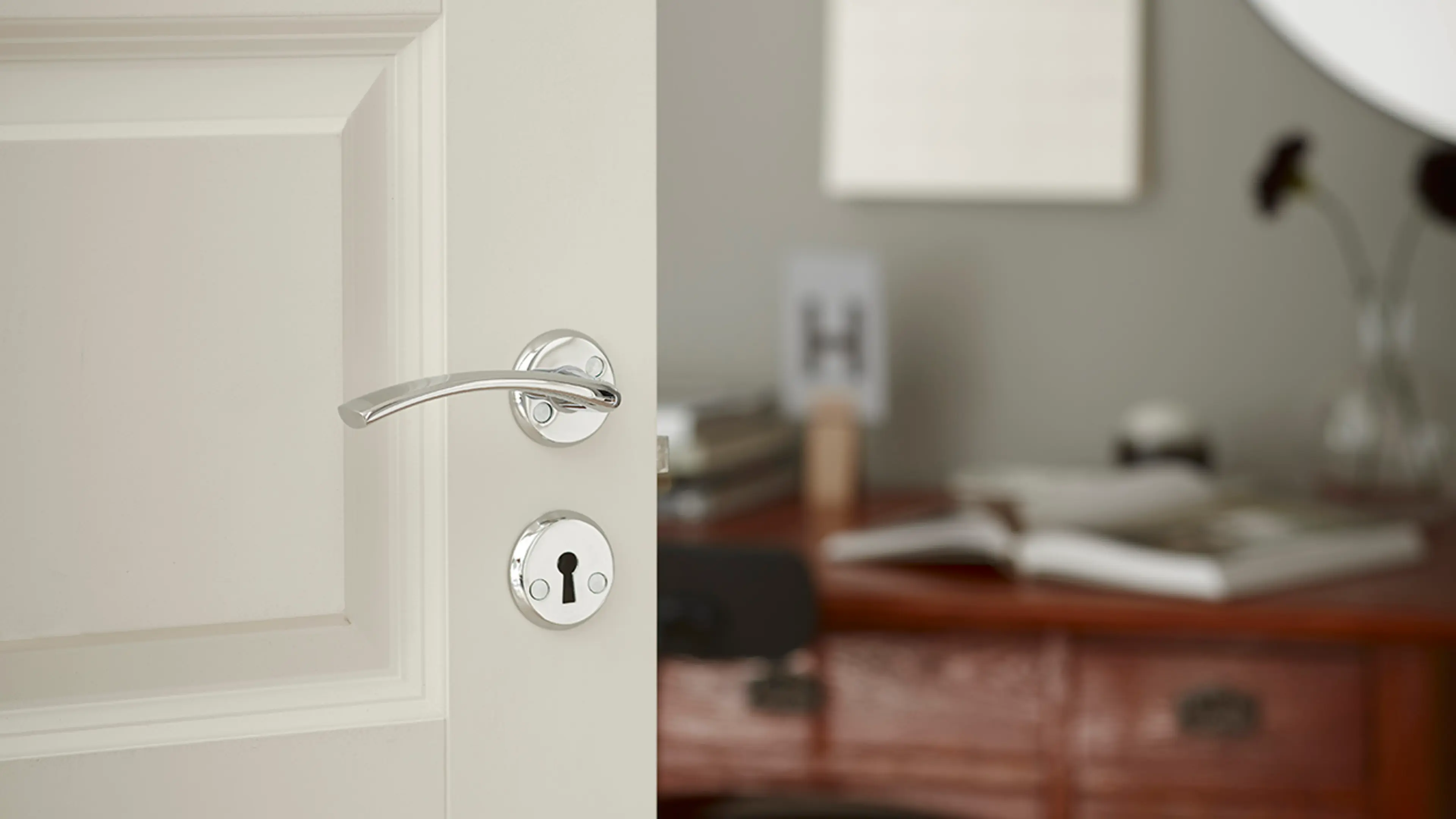 Dørhåndtak innerdør i krom på hvit dør.