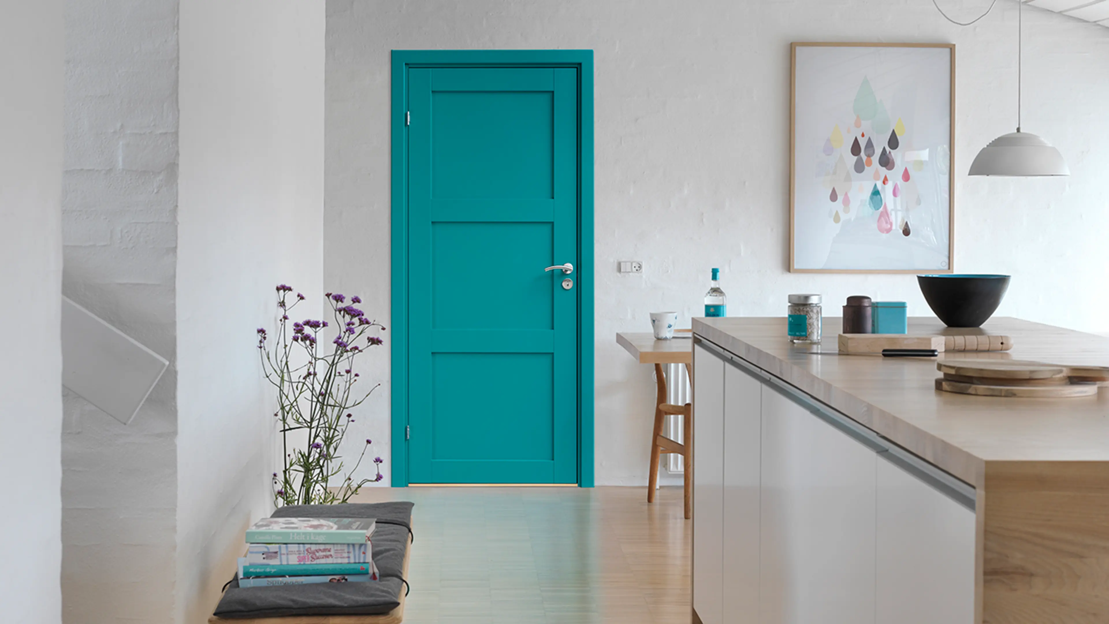 Turkis dør inne i hvitt kjøkken med hvite murvegger.