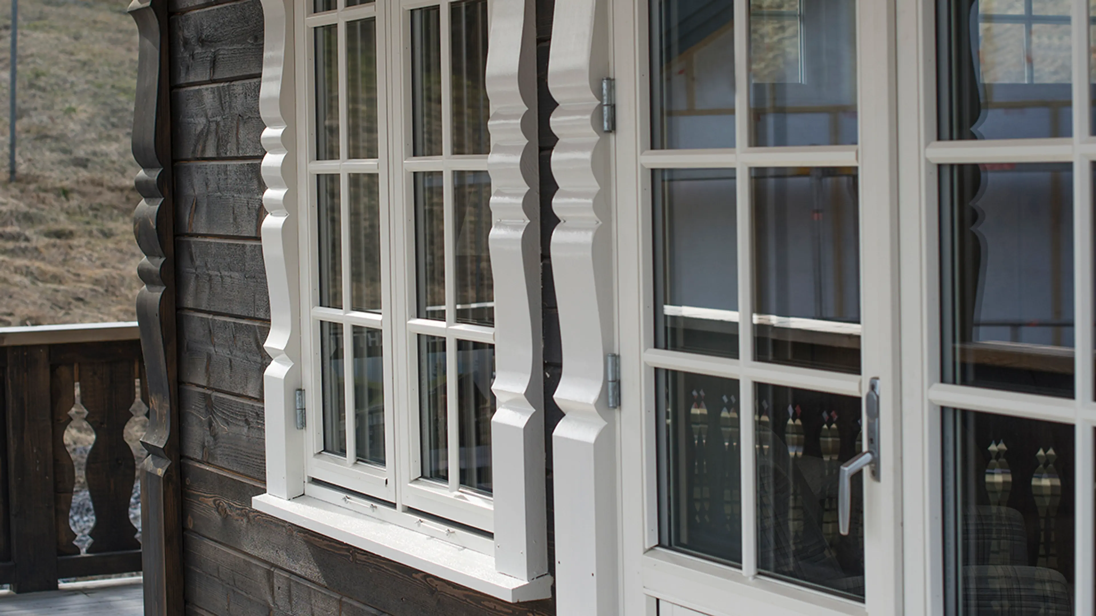 Hytte som har skiftet vinduer til nye vinduer med sprosser og utvendig karm med profil.
