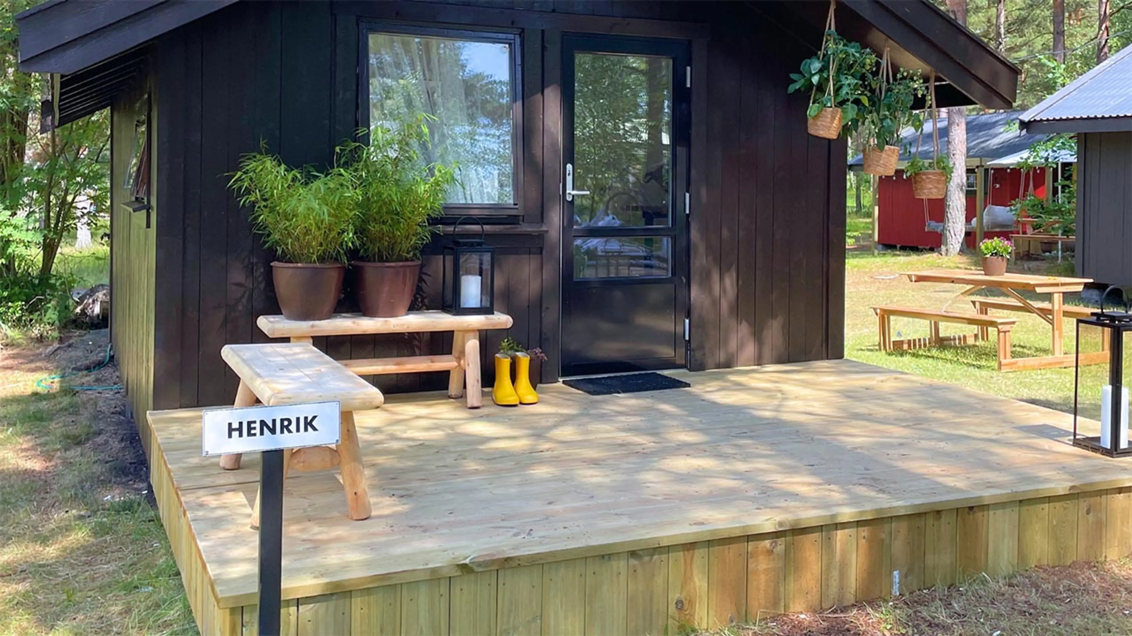 Terrasse bygget av bryggeplank utenfor liten hytte.