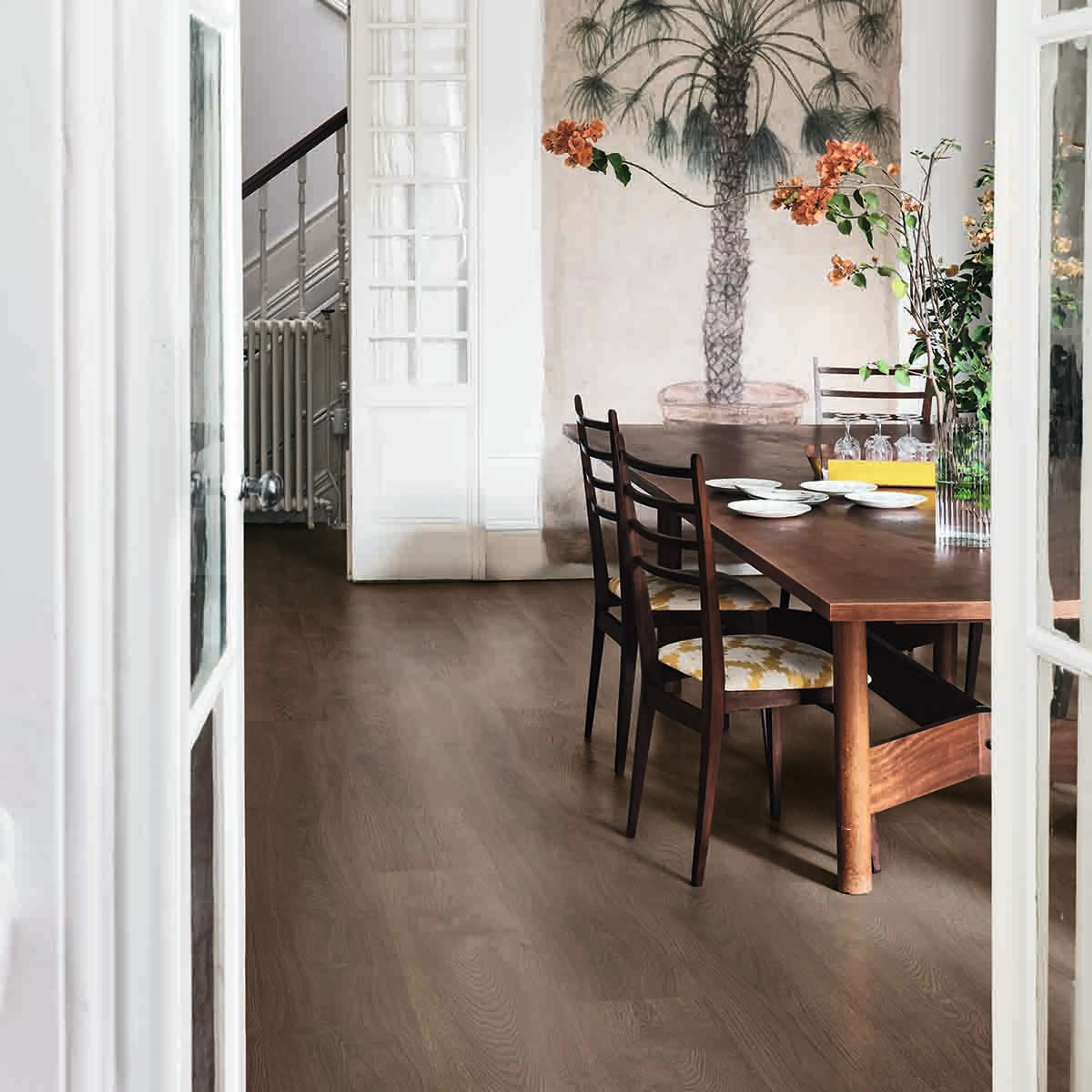 Mørkt gulv i spisestue med tremøbler og palmetapet