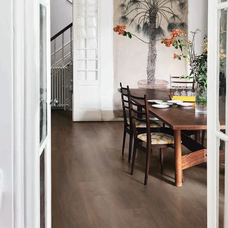 Mørkt gulv i spisestue med tremøbler og palmetapet