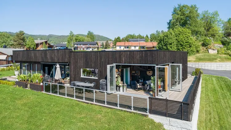 Funkishus med moderne utvendig kledning som er stående og stor terrasse.
