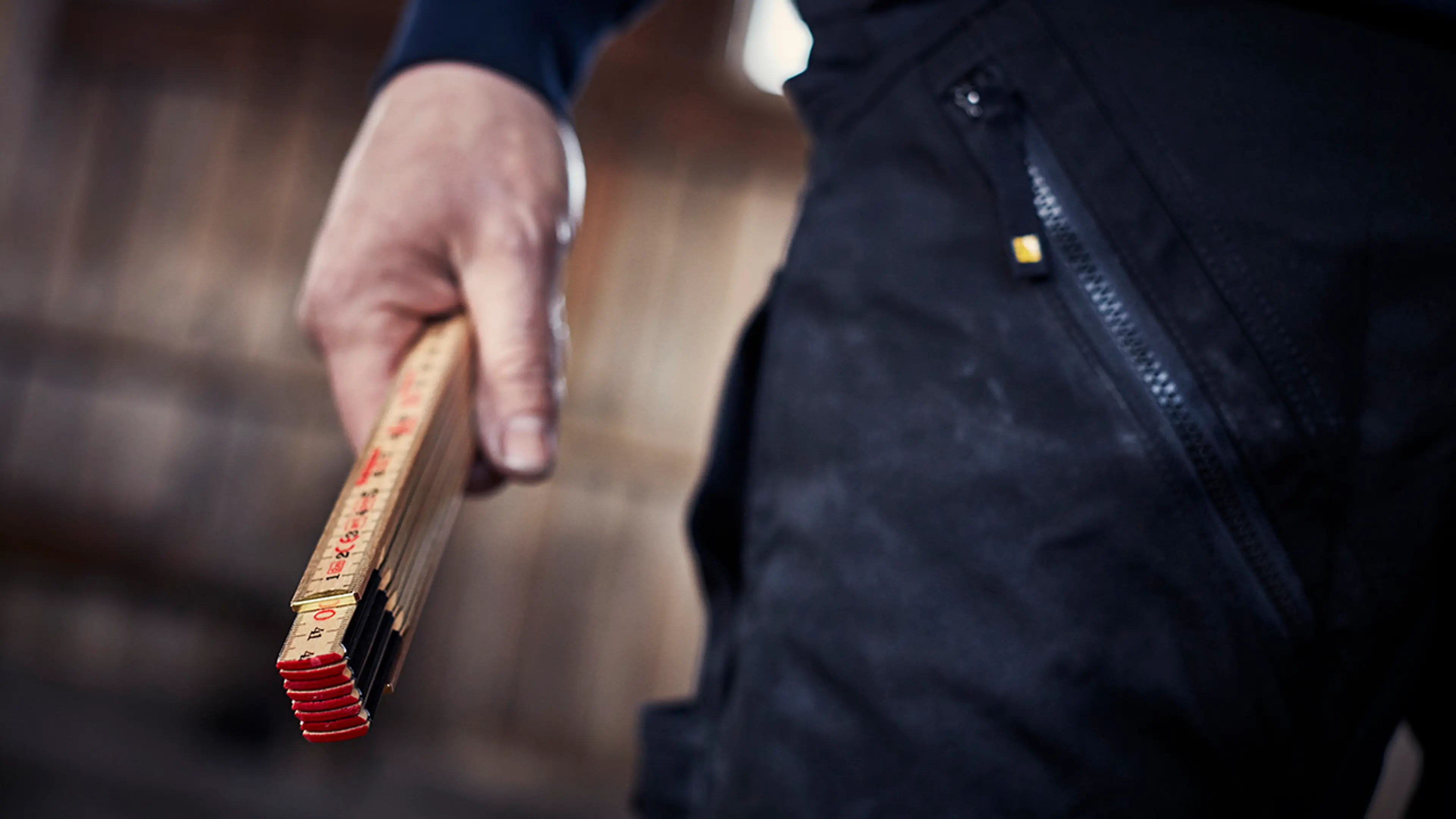 Person med tommestokk i hånda.