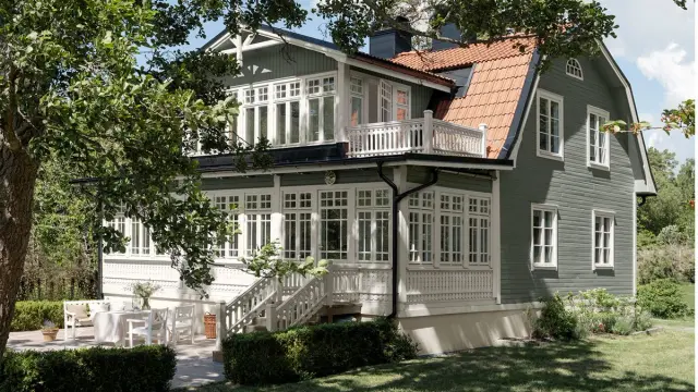 Stort grønt hus malt i 7653 Stockholmsgrønn med hvite detaljer på eksteriør i fargen 1024 Tidløs.