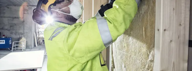 mann som isolerer vegg i hus