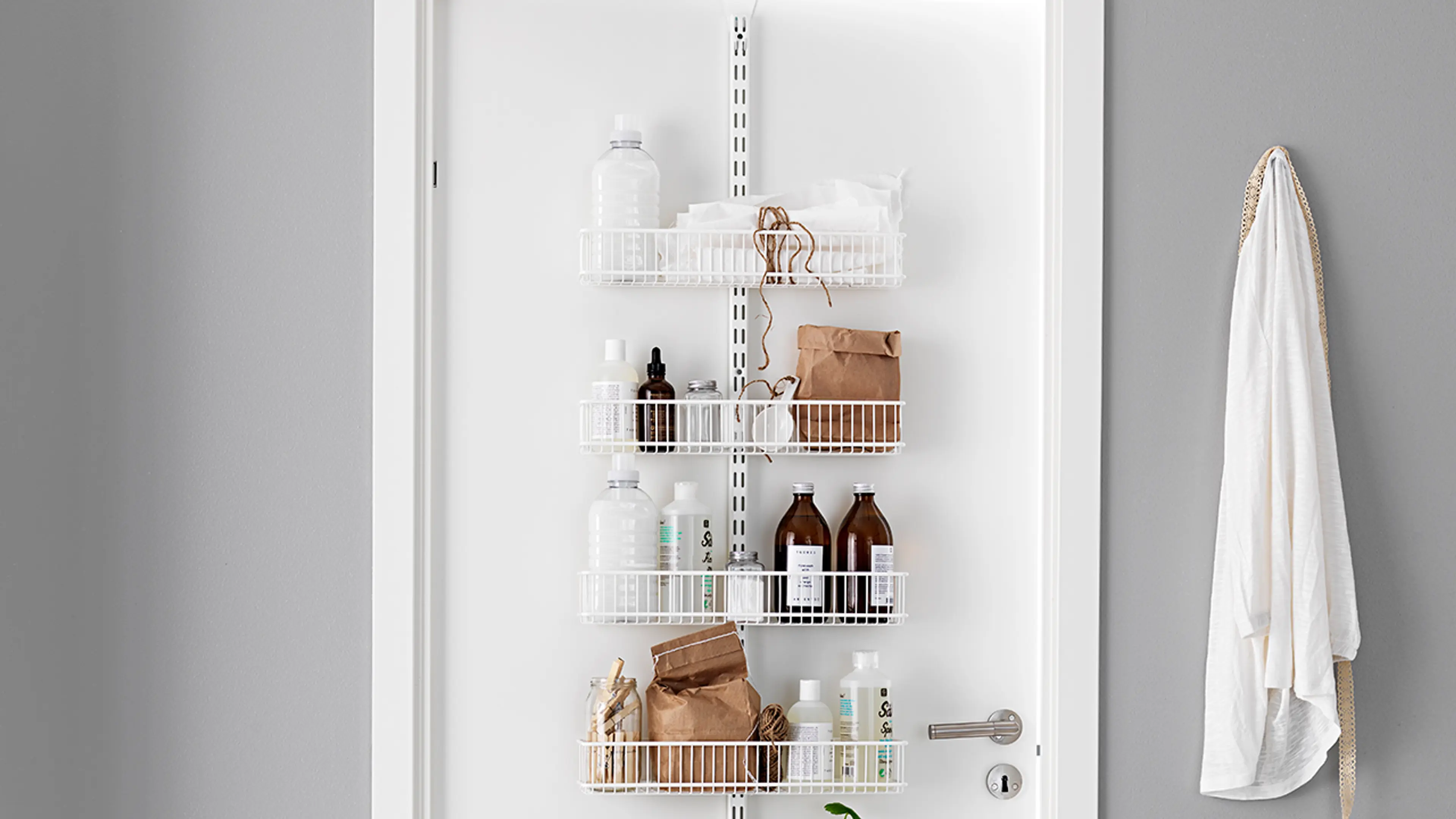 Døroppbevaring med trådkurver i lite hyttebad.