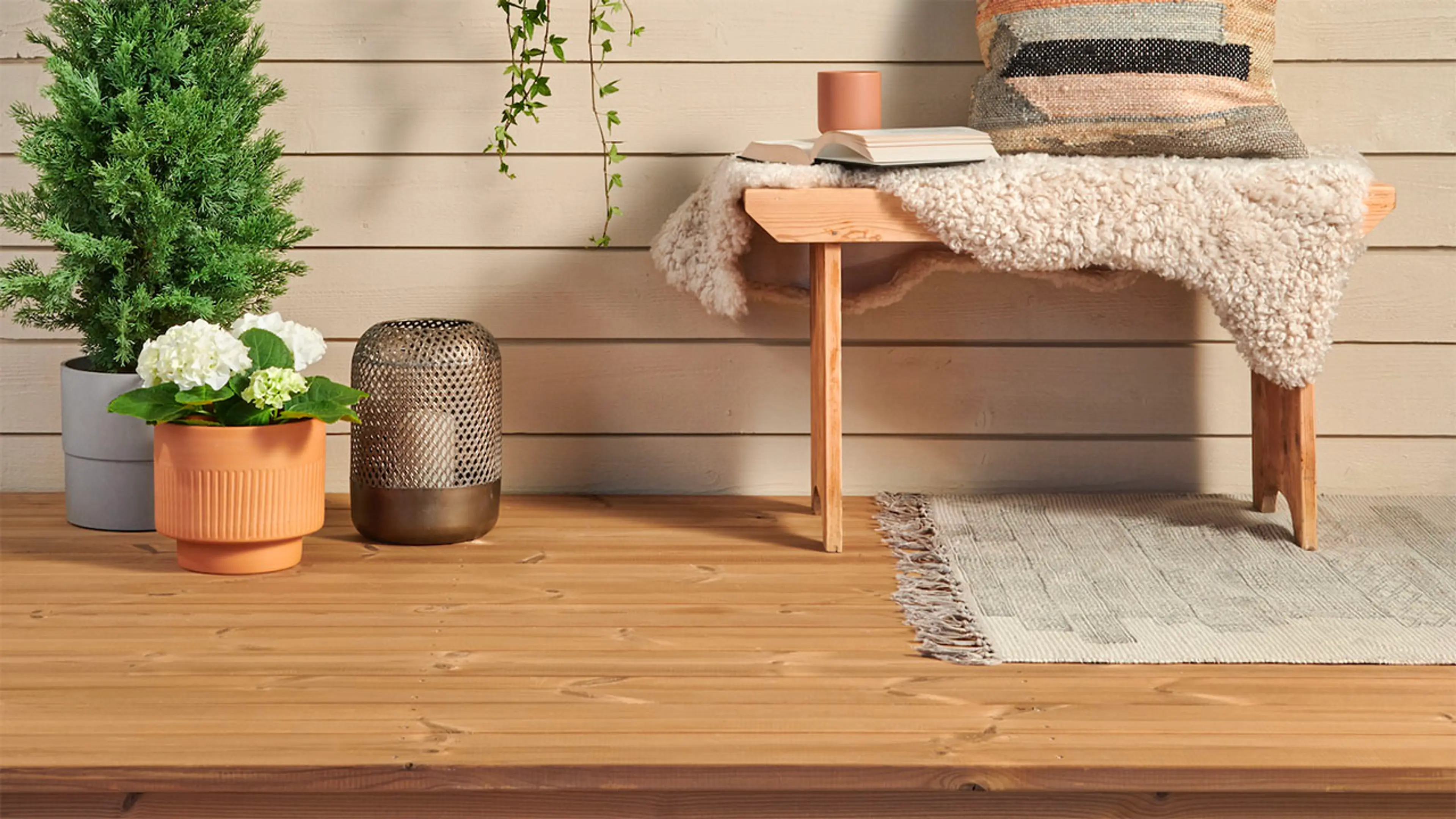 Termofuru terrassebord på terrasse med benk og planter.