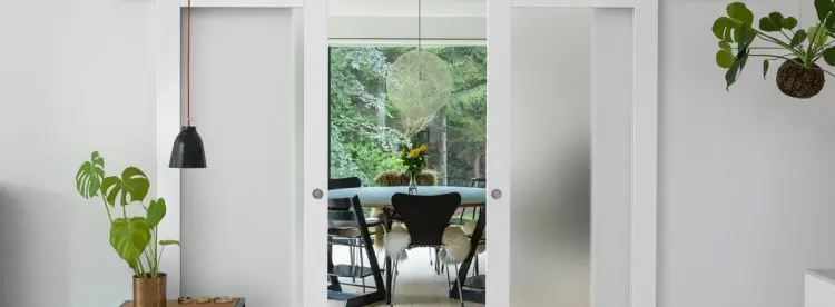 Innvendige skyvedører med frostet glass inn mot en spisestue