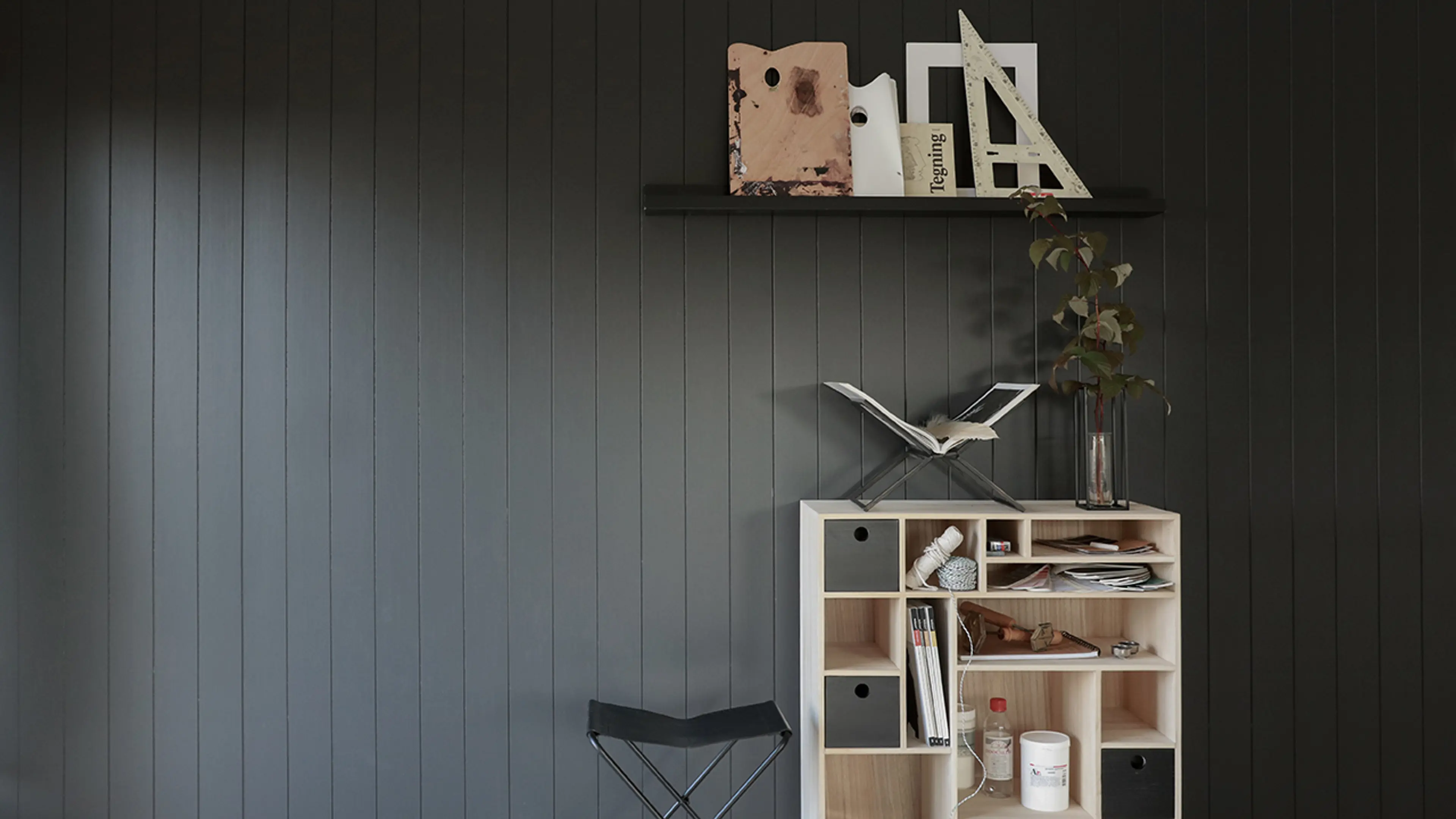 Stuevegg med Huntonit veggplater i Dempet Sort kombinert med sorte og lyse tremøbler.