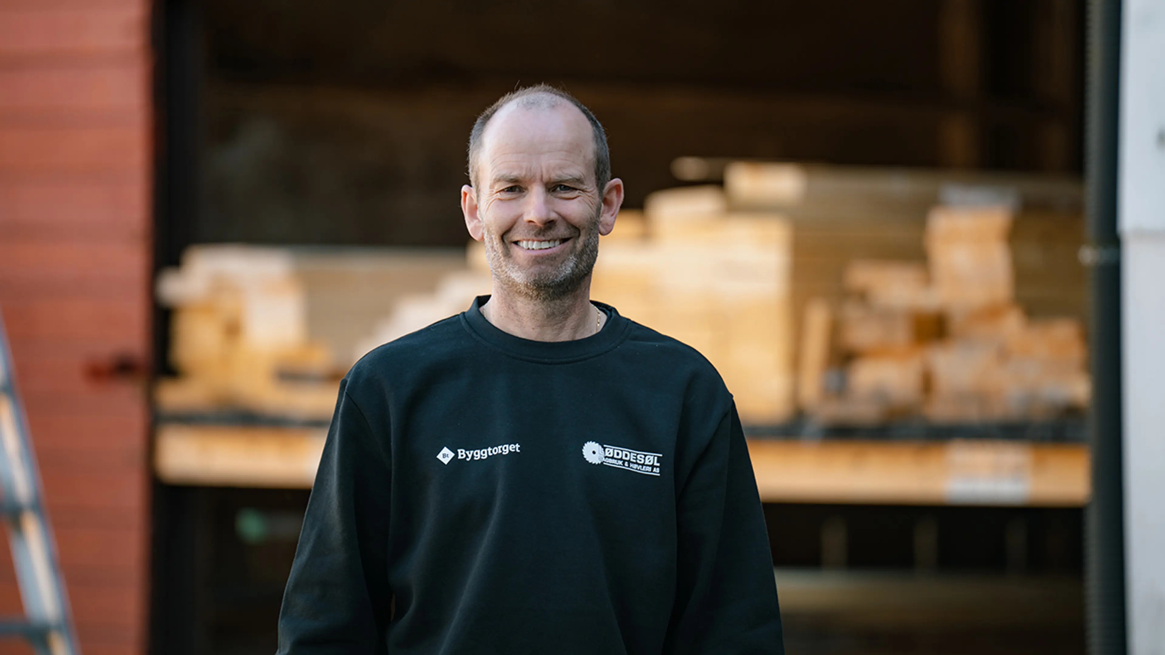 Byggtorget-ansatt foran lager med terrassebord.