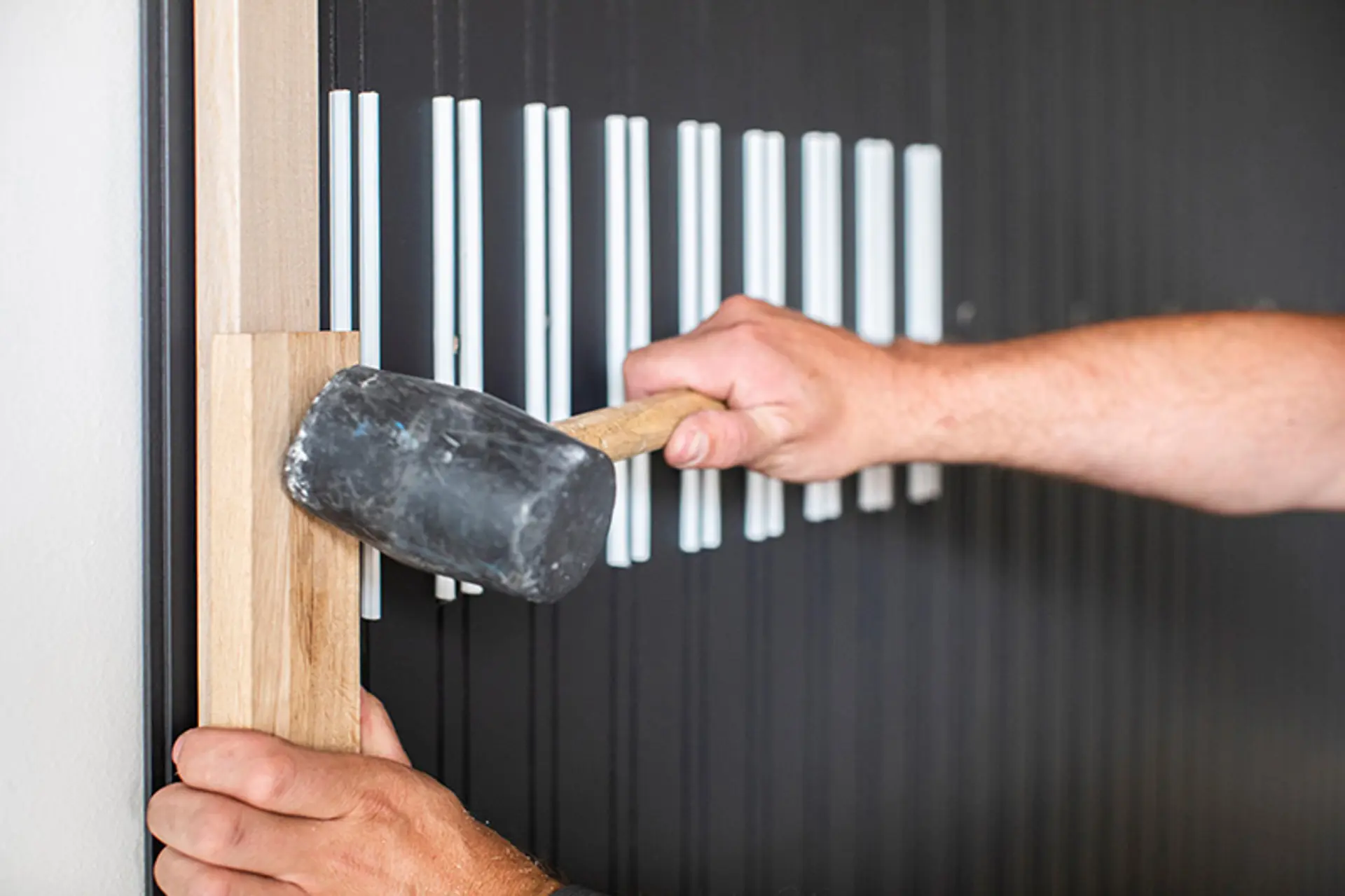 mann monterer spilepanel på vegg