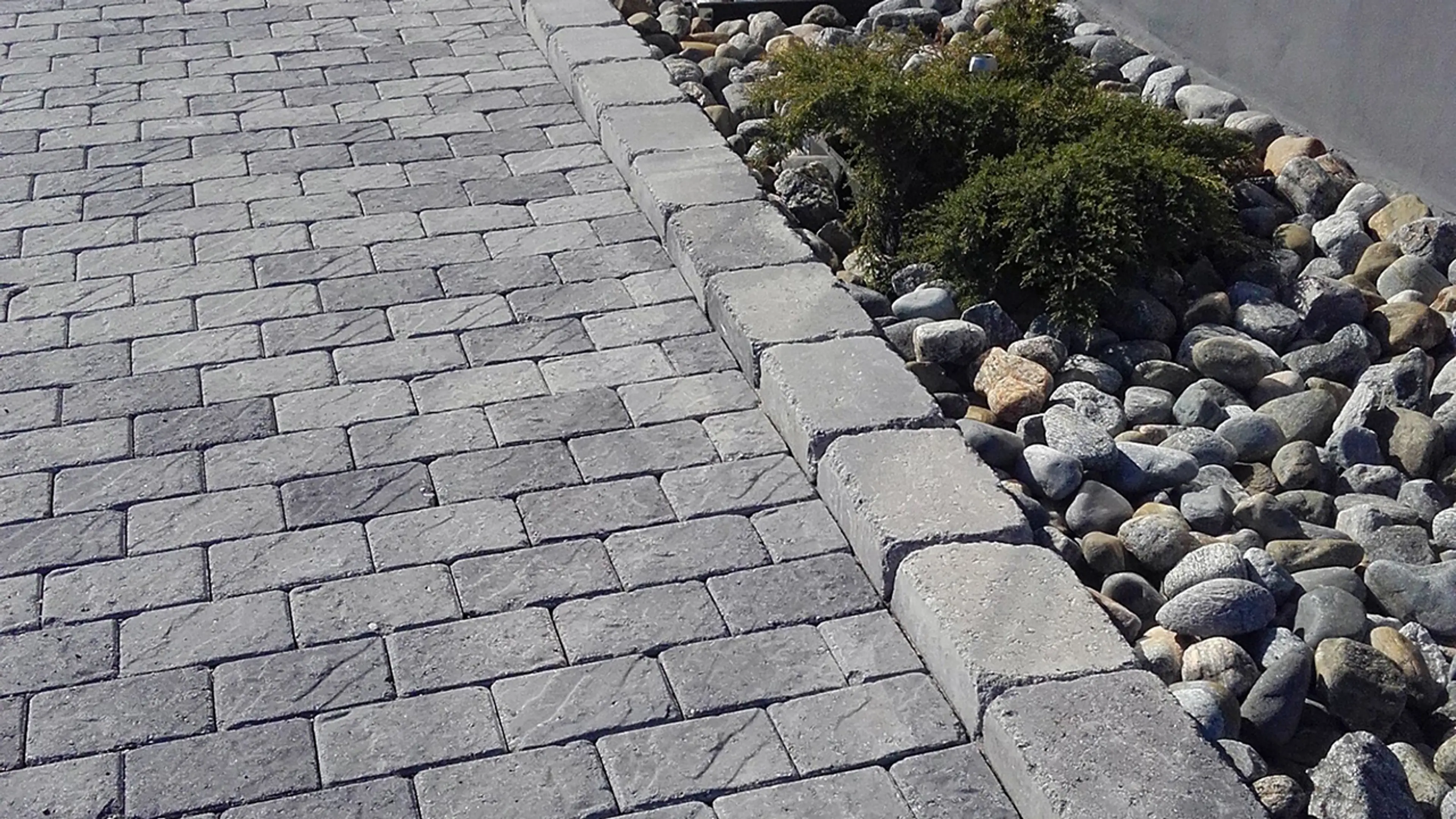 Gangsti med Aas Royal Baron belegningsstein og blomsterbed med kantstein og elvestein.