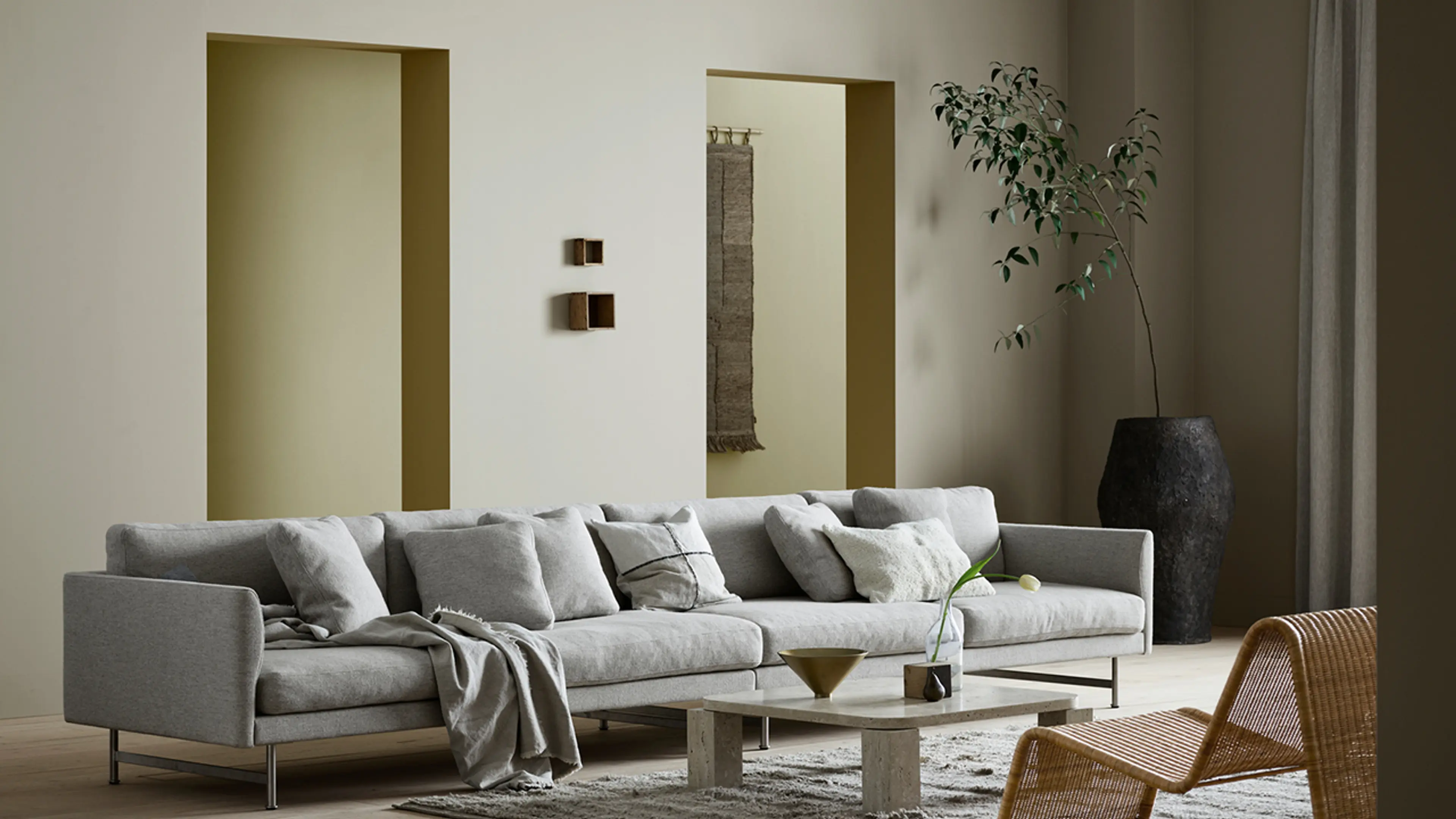 Stue med stor sofa og Jotuns nye trendfarger 12290 Antwerp Beige, 12075 Soothing Beige, 8583 Earthy Yellow og 0288 Mexico.