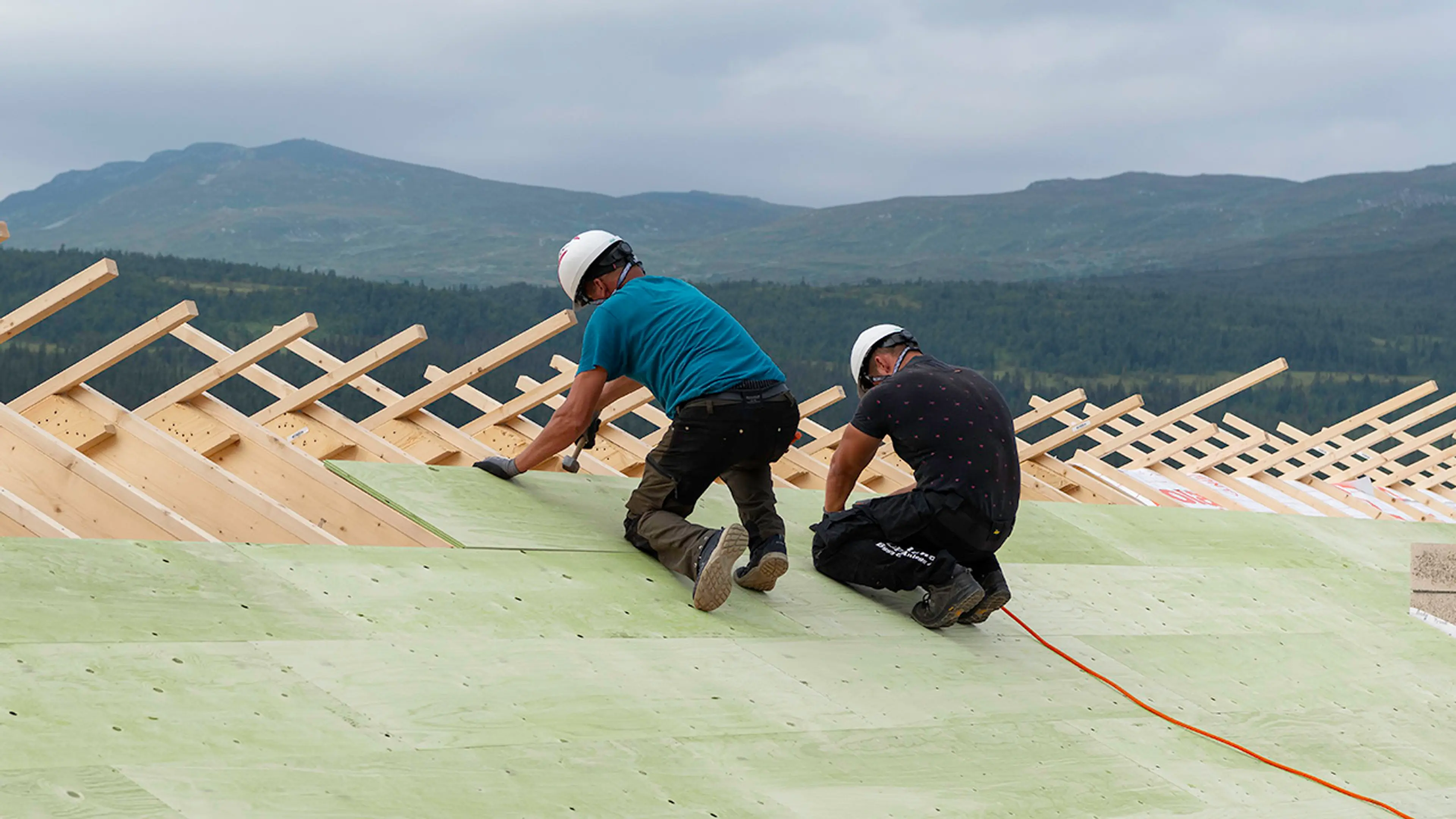 Personer som legger konstruksfiner på tak.