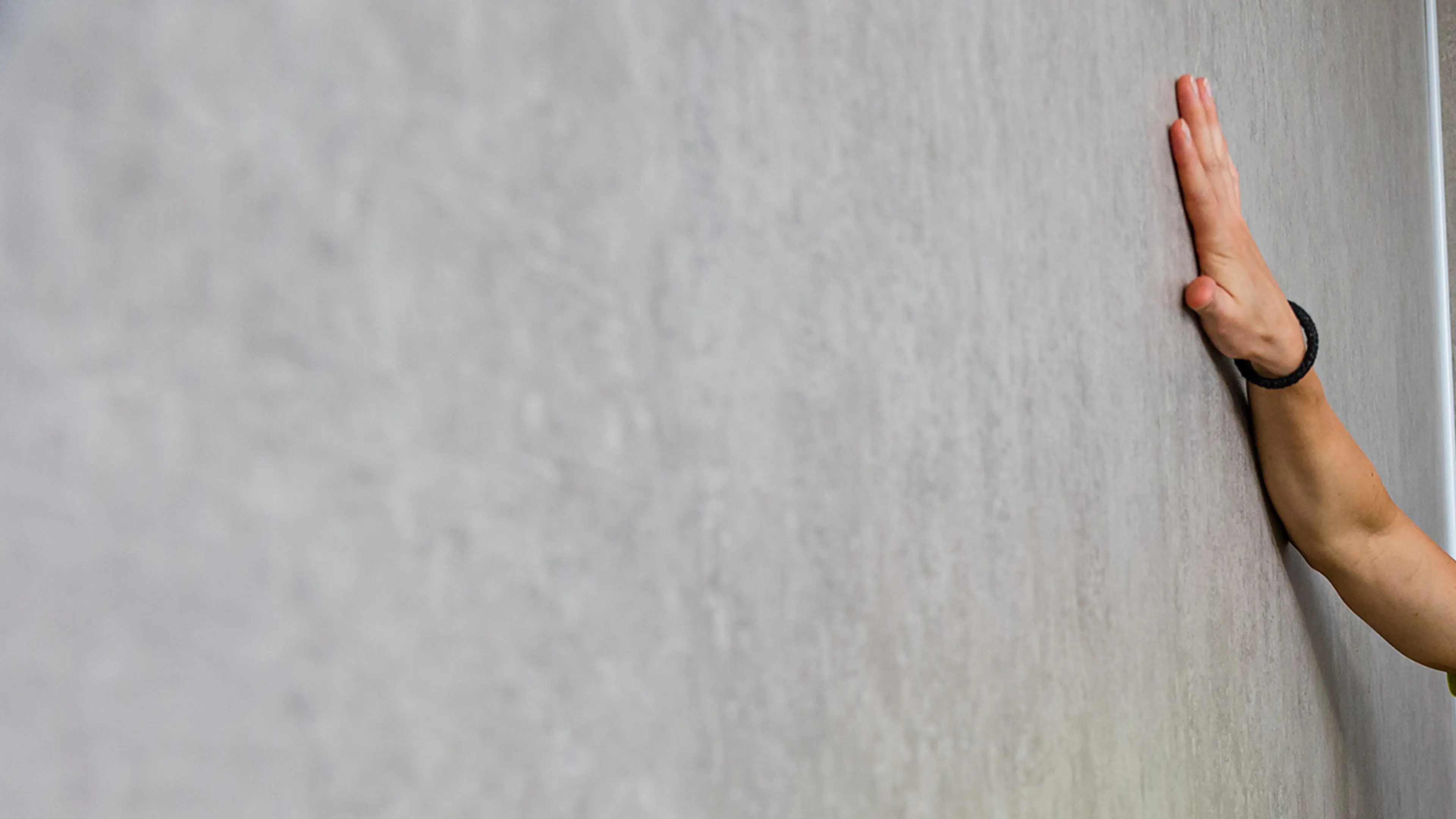 Grå vegg og hånd som stryker over.