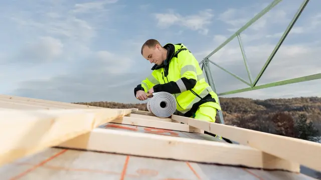 Håndverker som rehabiliterer tak.