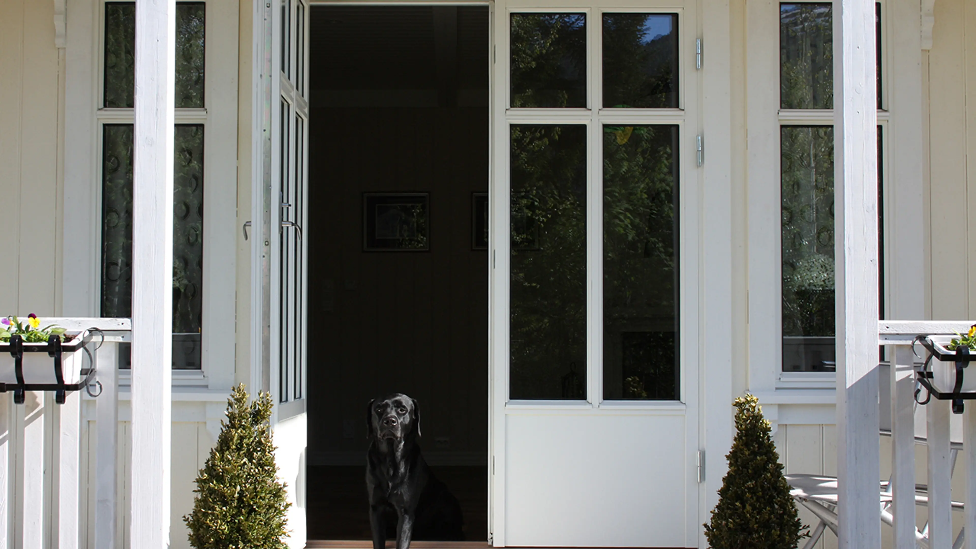 Hvitt hus med dobbel verandadør med sprosser.