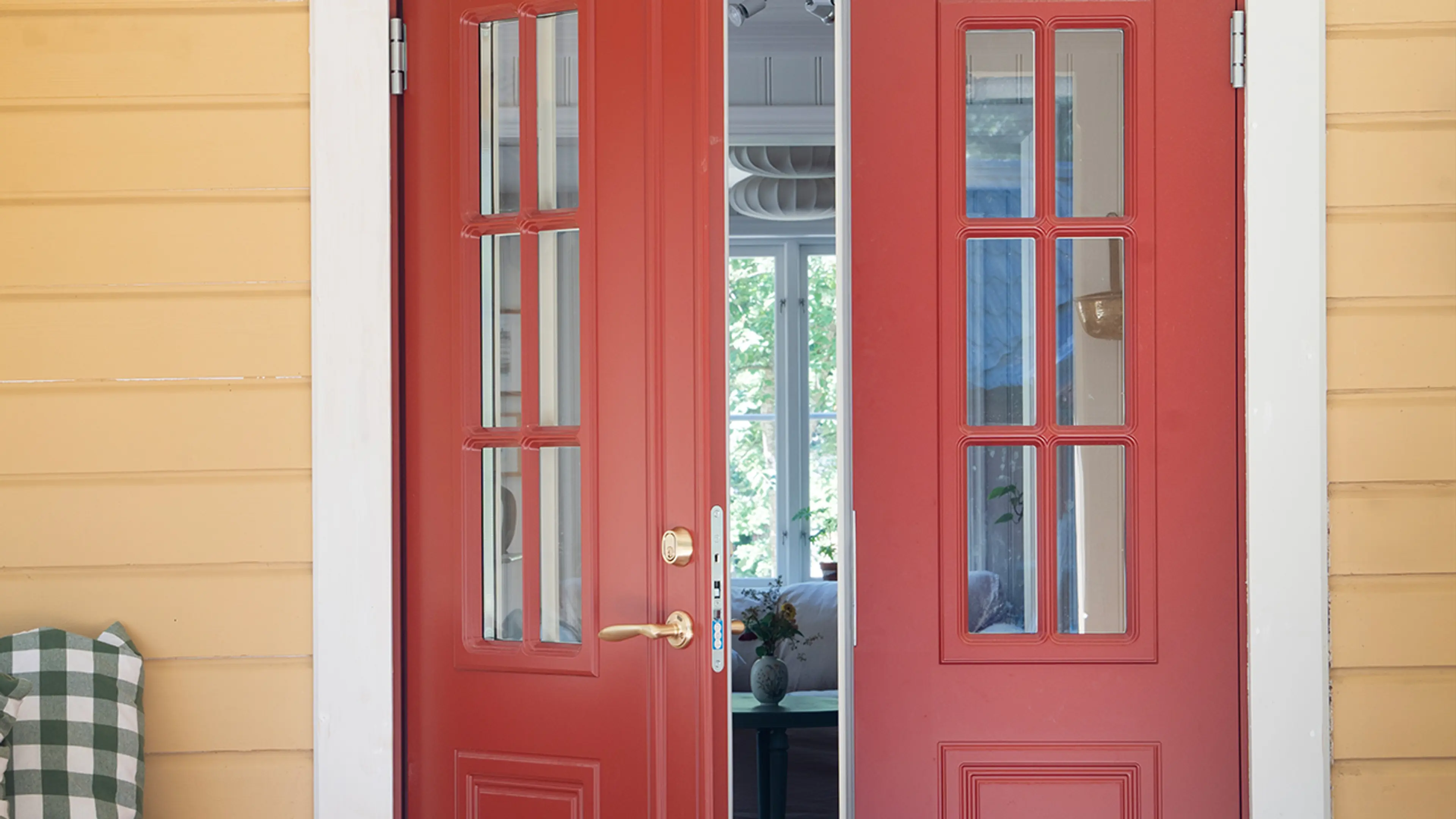 Gult hus med klassisk tofløyet ytterdør i rød.