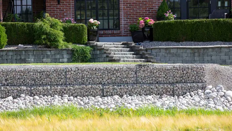 To ulike billige støttemurer i hage foran hus.