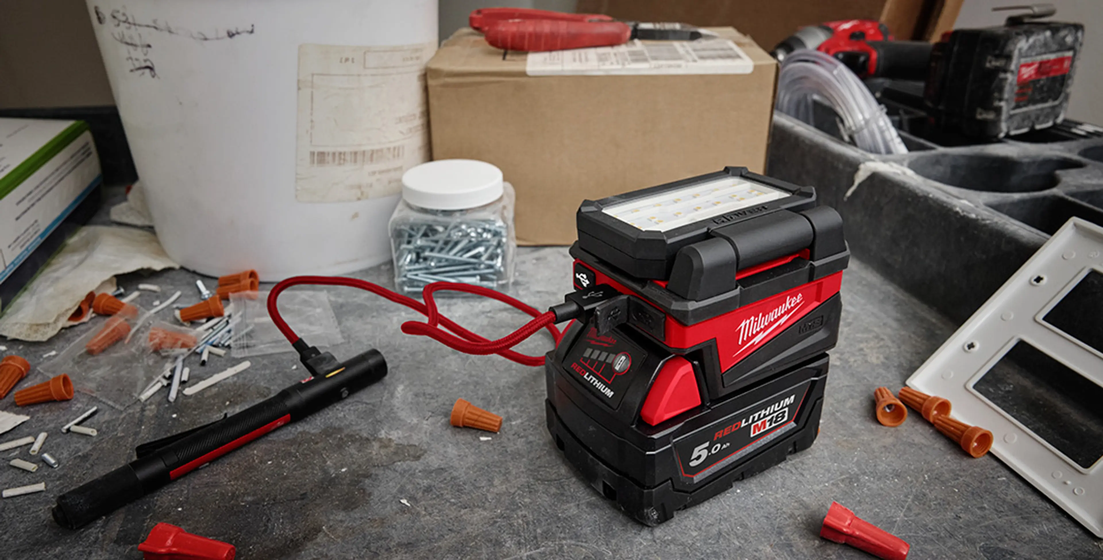 Arbeidslampe M18 ALIS fra MILWAUKEE® som er foldet sammen blant annet utstyr.