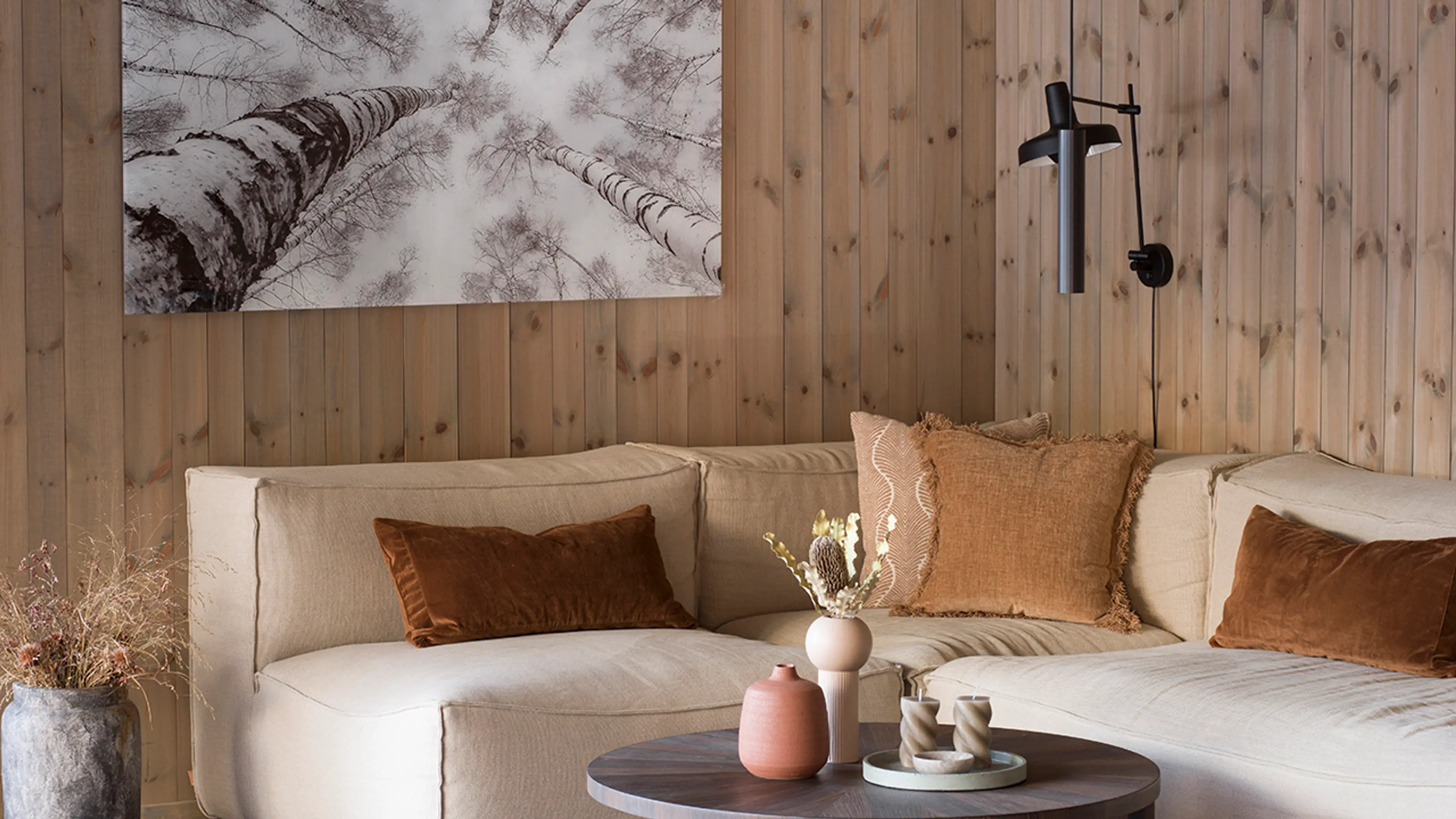 Beiset panel i stue med lys sofa.