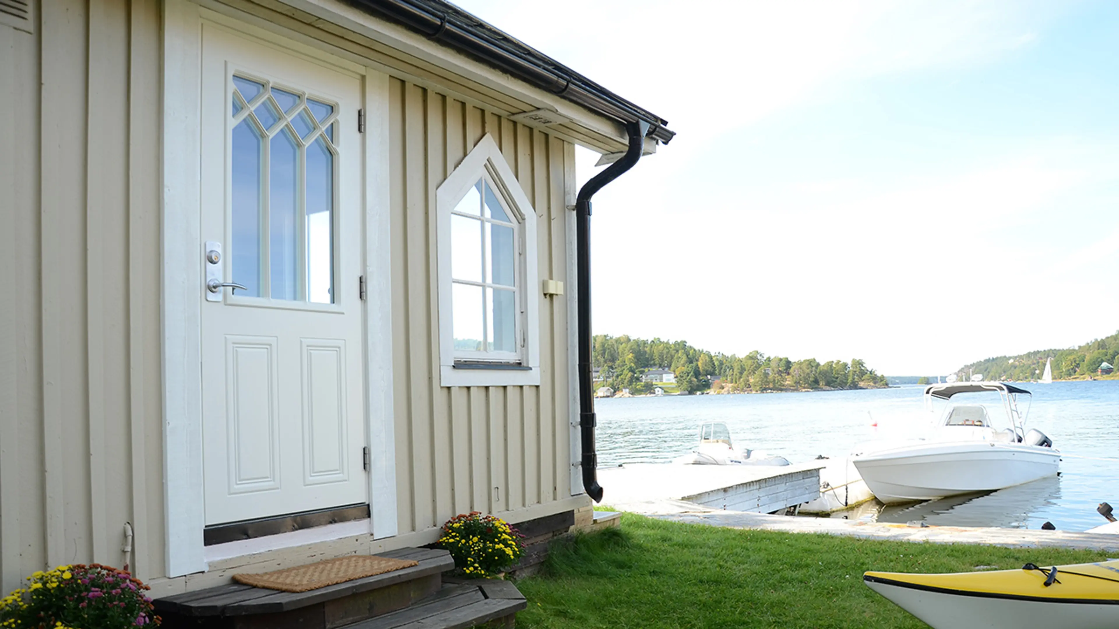 Klassisk ytterdør på hus ved sjøen med brygge.