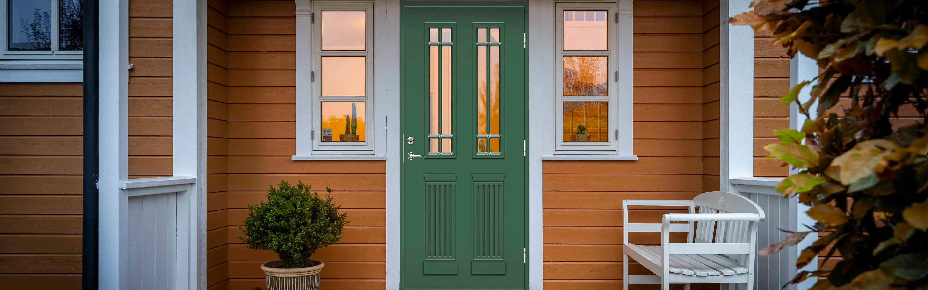 Male ytterdør grønn på gult hus.