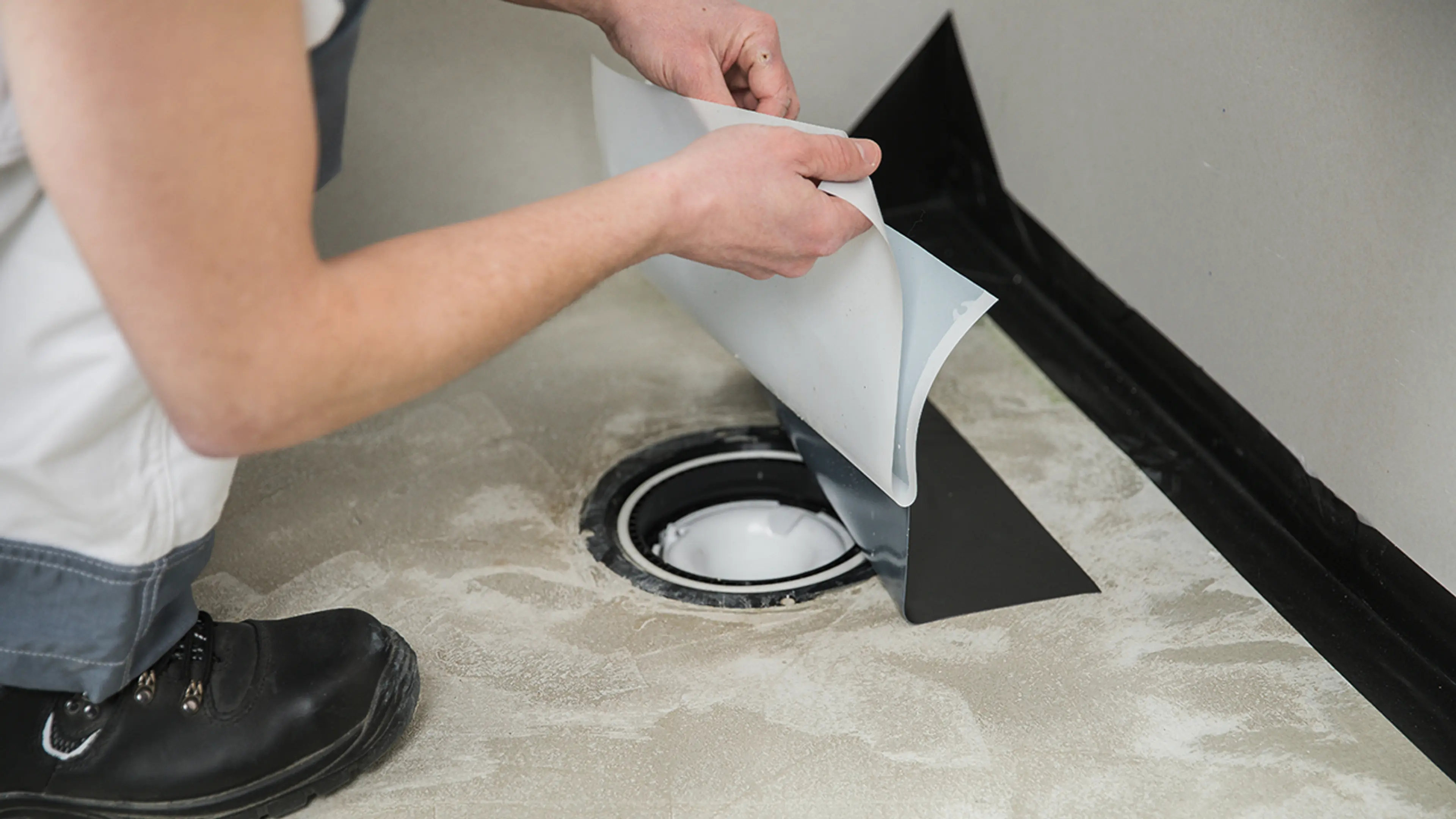 Håndverker som legger slukmansjett på baderom.