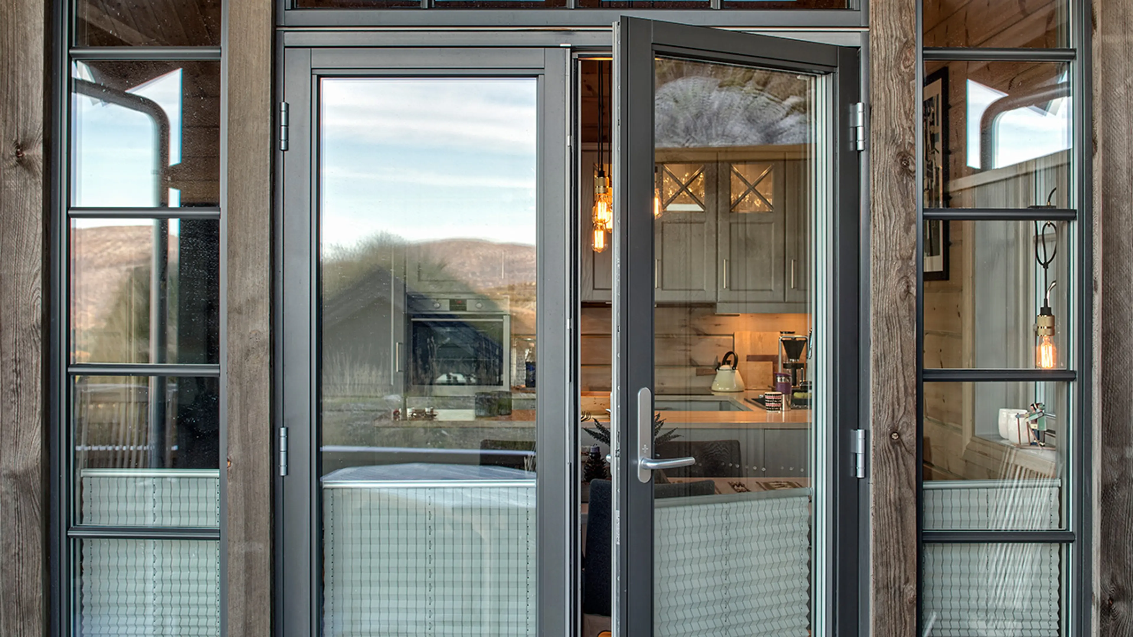 Hytte med dobbel verandadør i sort med sidefelt.