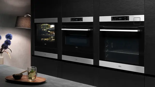 Høyskapsvegg med dampovn og kombiovn i mørkt kjøkken.