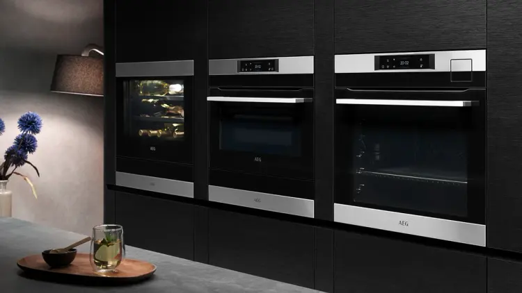 Høyskapsvegg med dampovn og kombiovn i mørkt kjøkken.