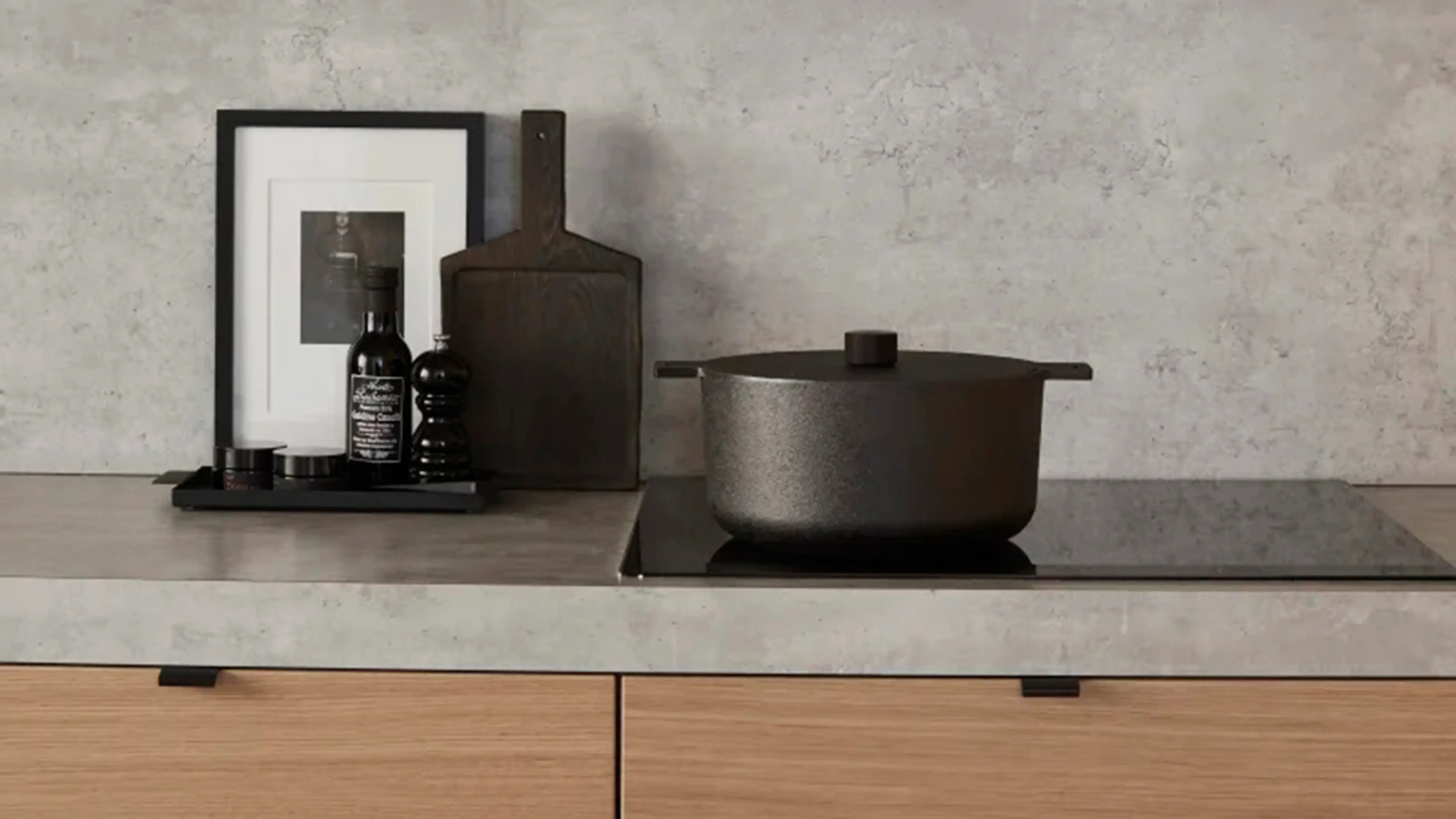 Grå laminat benkeplate og koketopp med kjele på i kjøkken med fronter i eik.