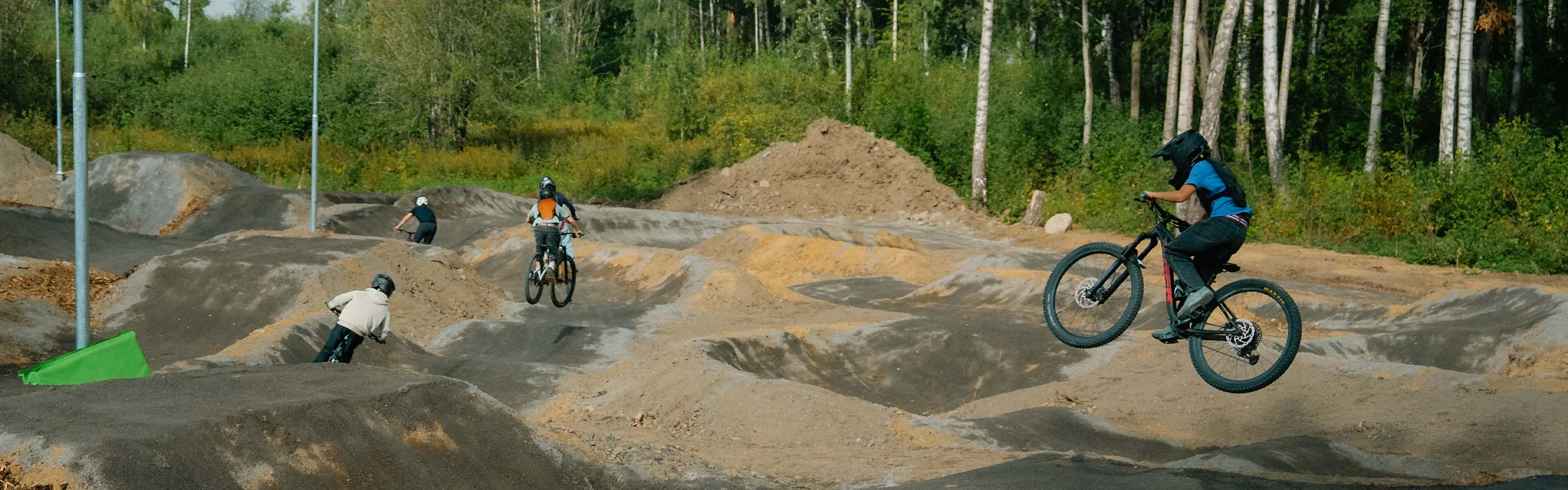 Ungdommer som hopper og sykler på hinder i en sykkelpark.