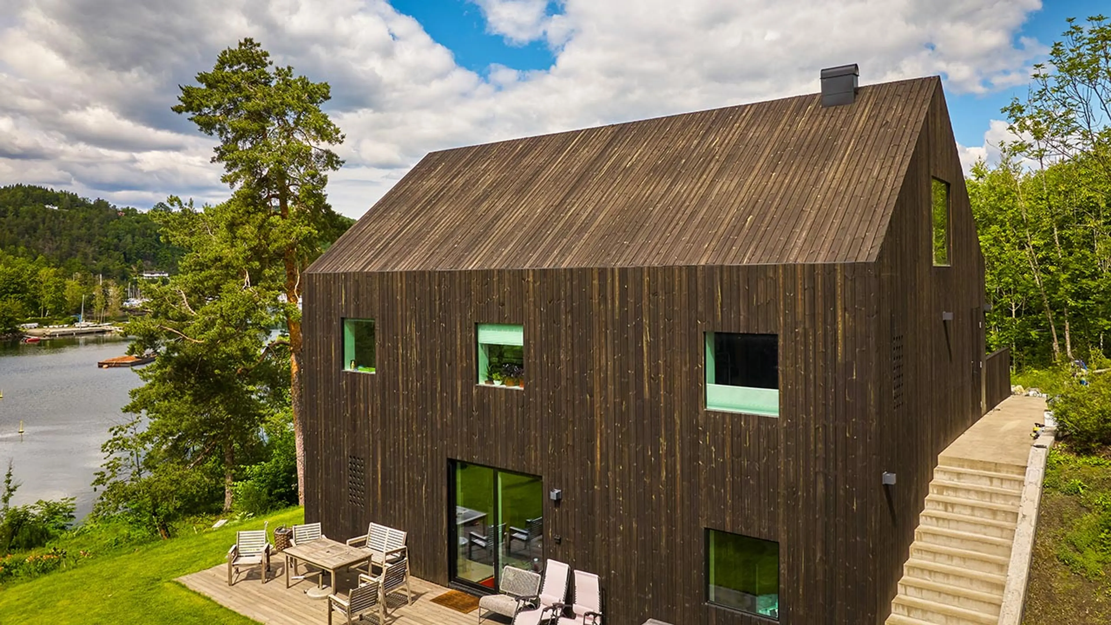 Hus ved vann med royalimpregnert kledning.