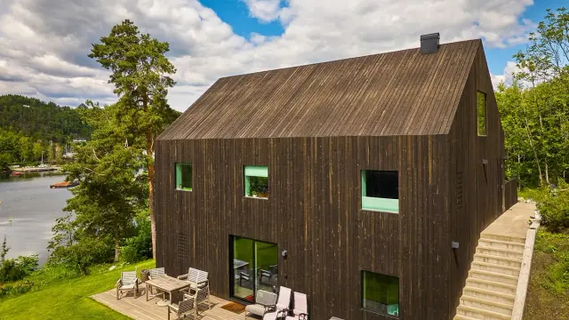 Royal impregnert kledning på hus ved vann.