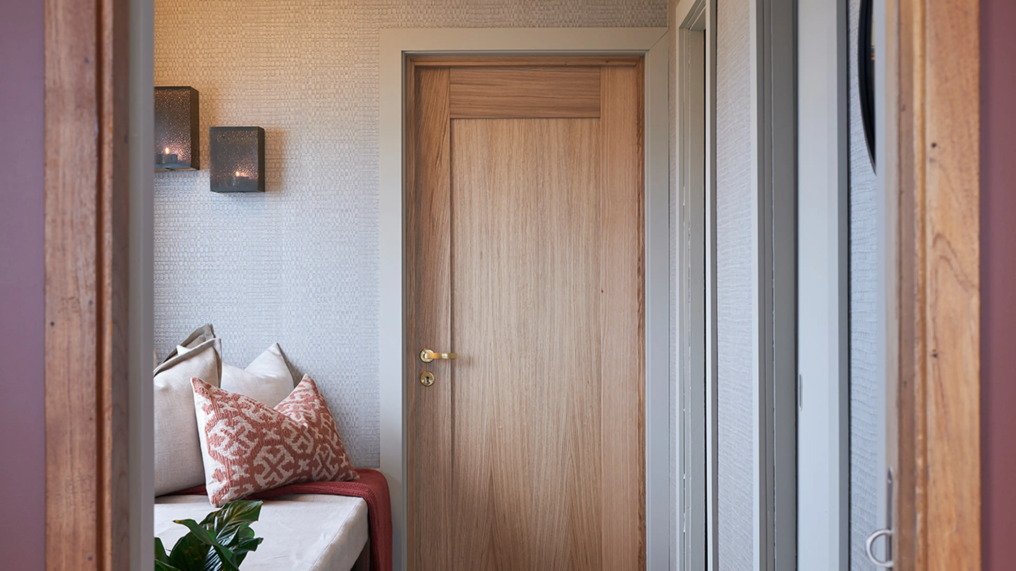 Gang med innerdør i eik og dørhåndtak og dørvrider i gull.