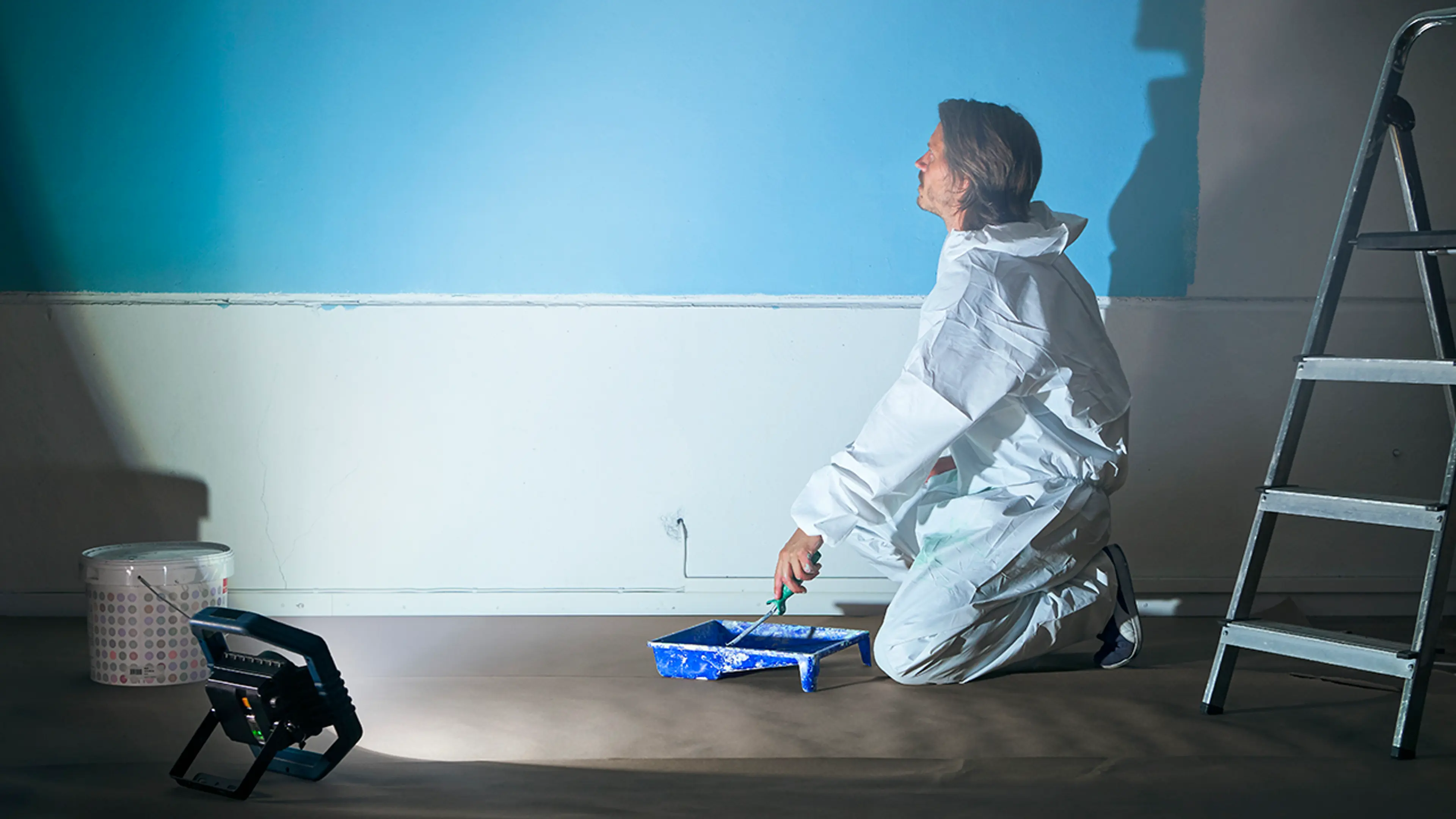 En maler som jobber i et rom lyst opp av en arbeidslampe med god fargegjengivelse.