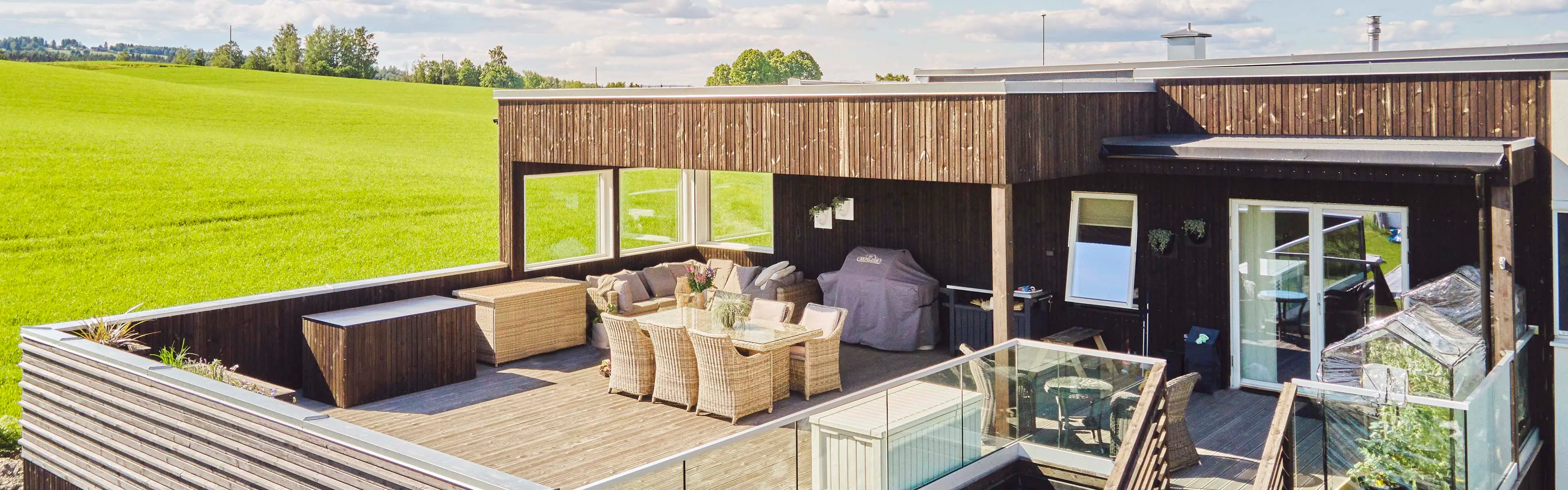 Takterrasse på funkishus i sommersol.