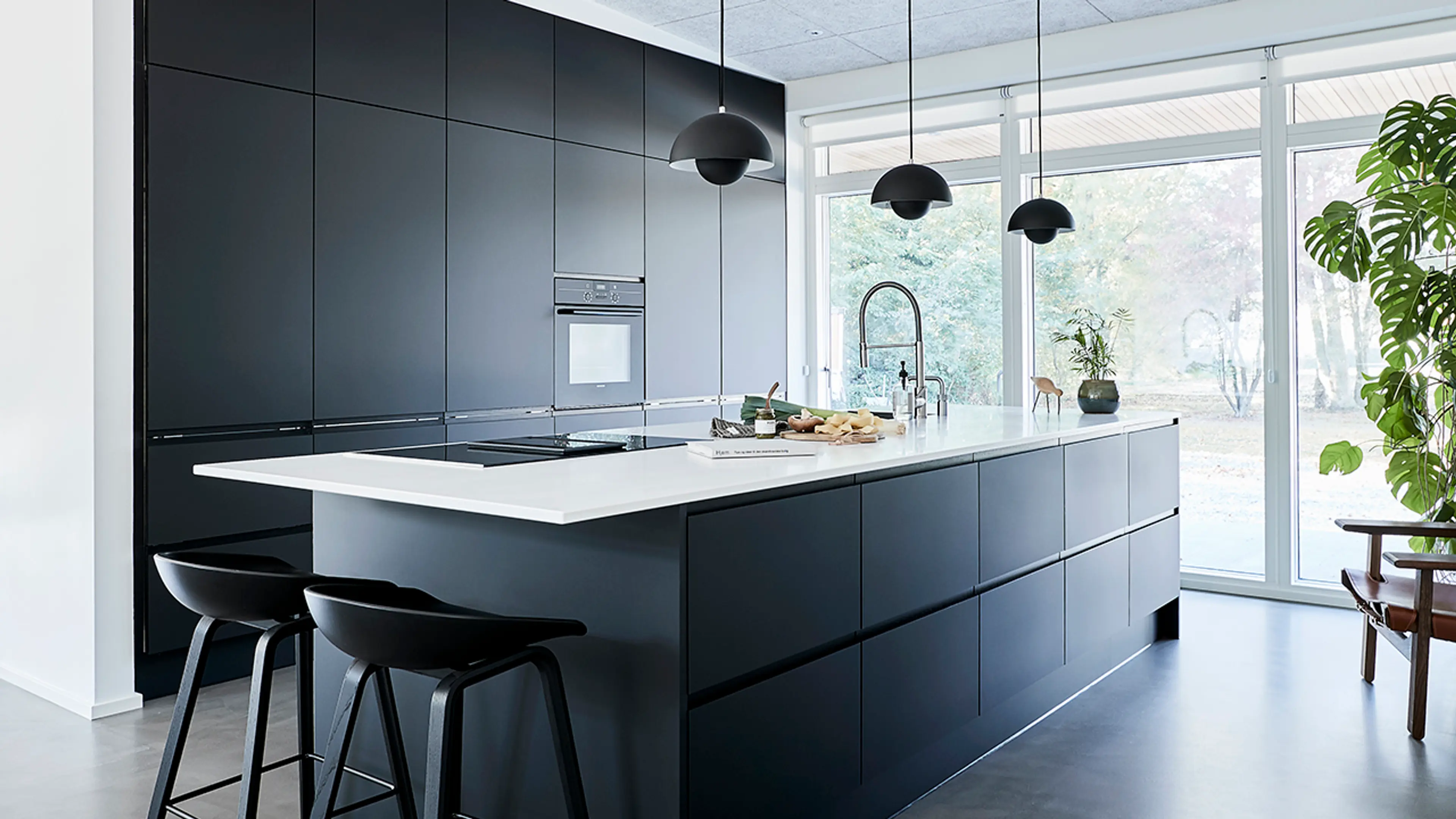 Kjøkken med kjøkkenøy med mørk innredning.